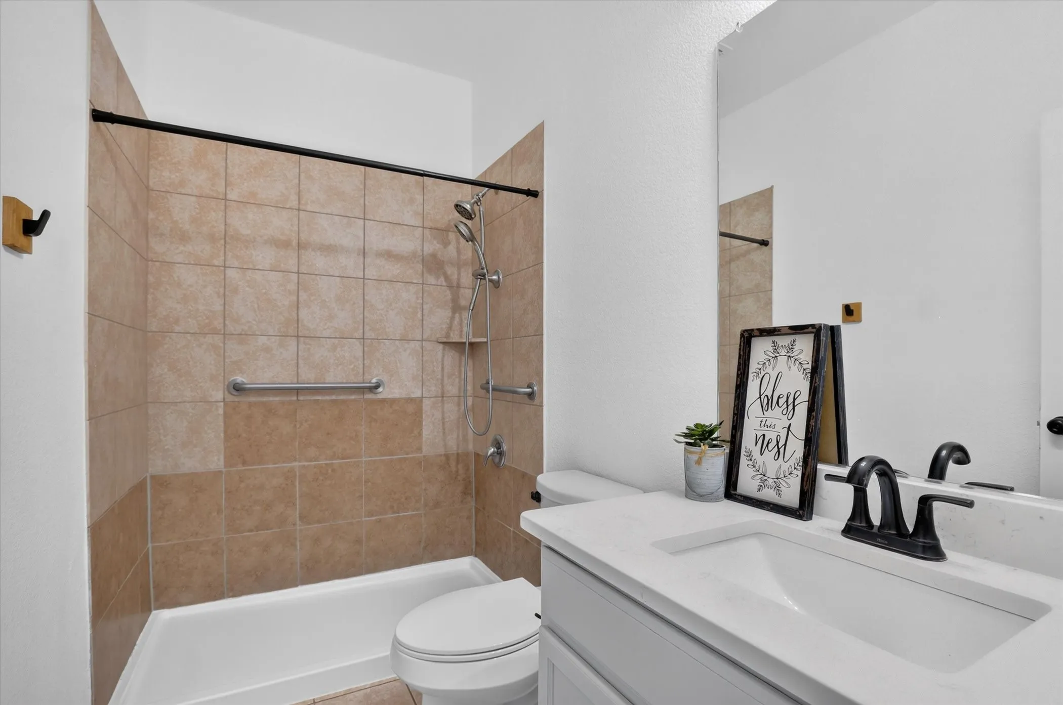 Modern bathroom featuring dual vanity with white rectangular vessel sinks, matte black fixtures, and a spacious walk-in shower with tile surround and glass enclosure