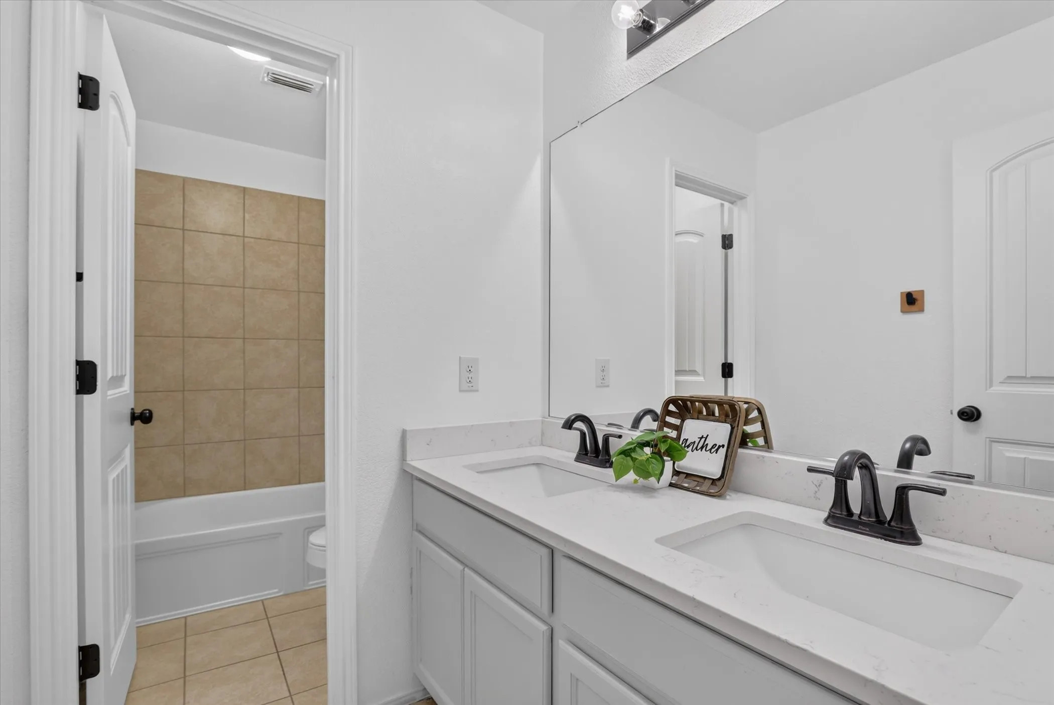 Double vanity with integrated sinks, quartz countertop, and matte black fixtures