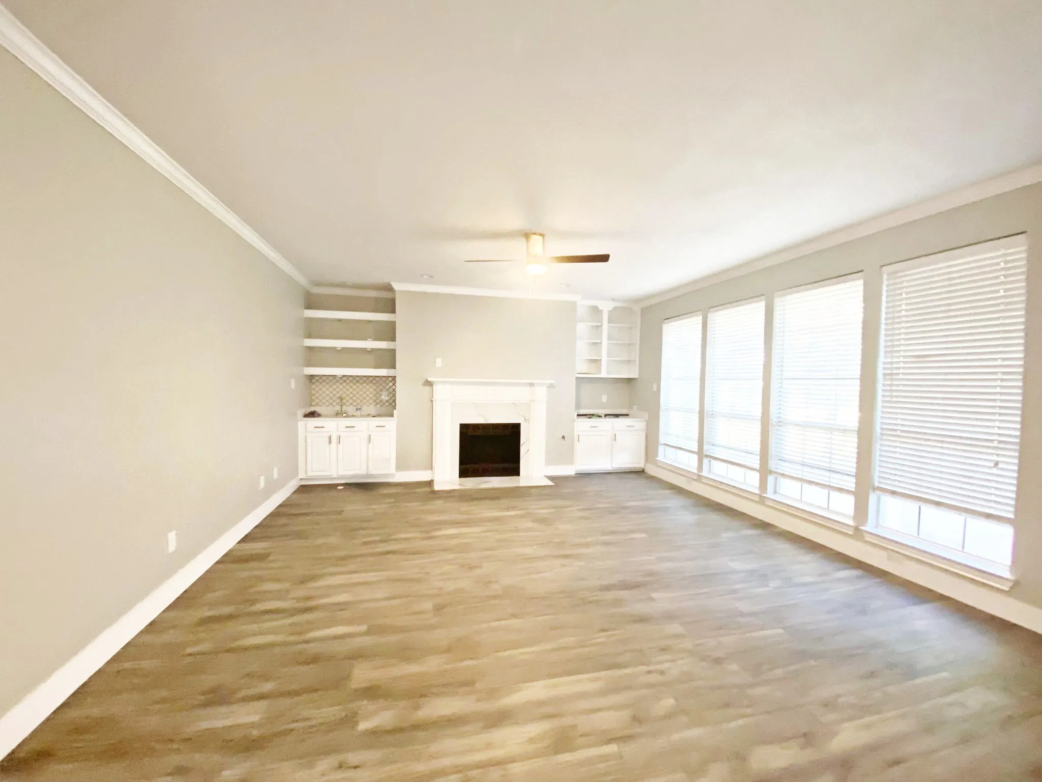 living room with hardwood / wood-style floors, ceiling fan, ornamental molding, and a premium fireplace