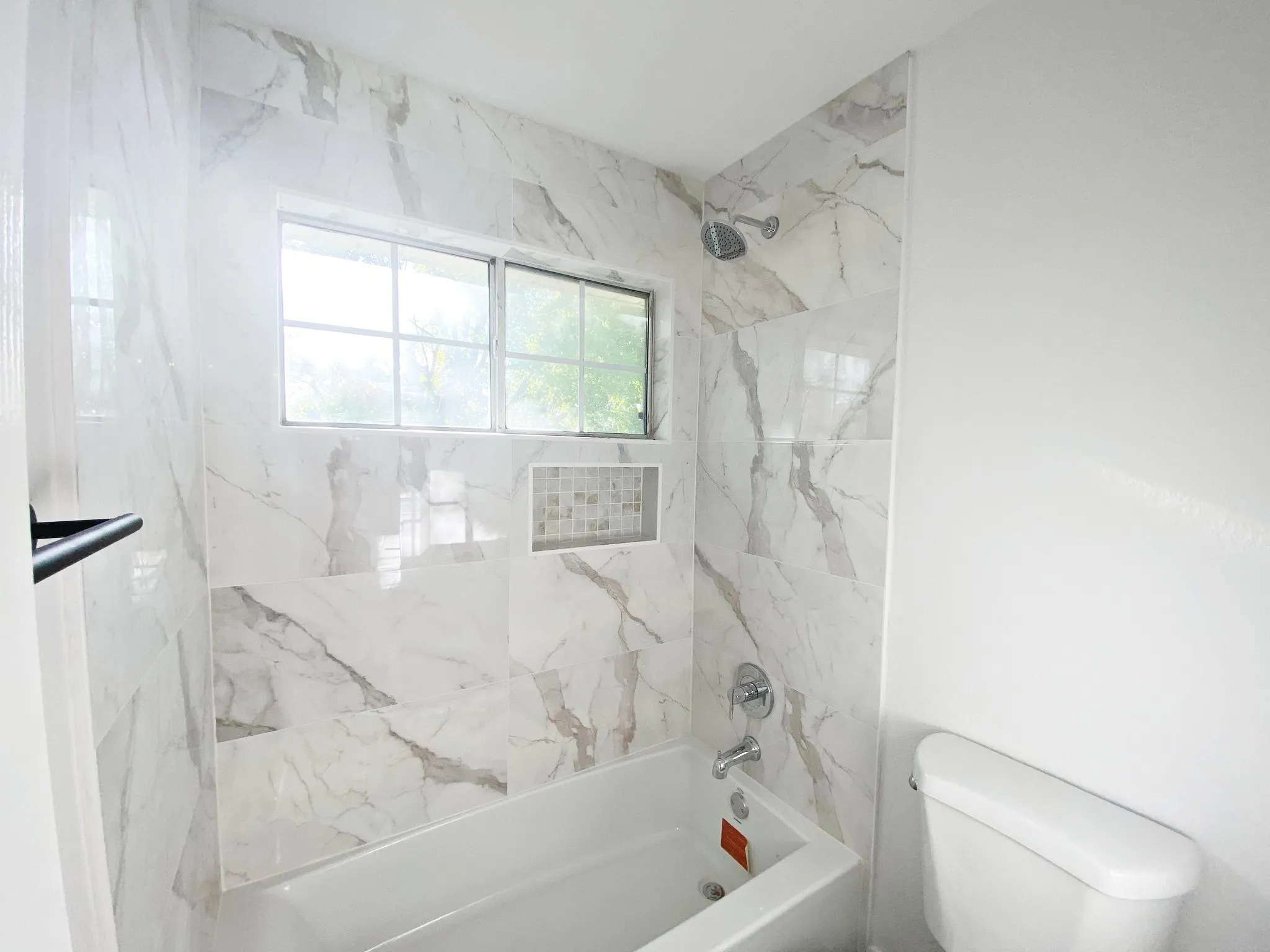 Bathroom with tiled shower / bath and toilet