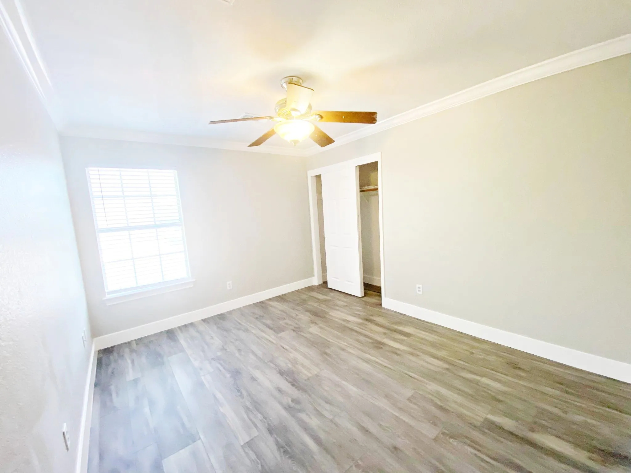 Spare room with ceiling fan, crown molding, and hardwood / wood-style flooring