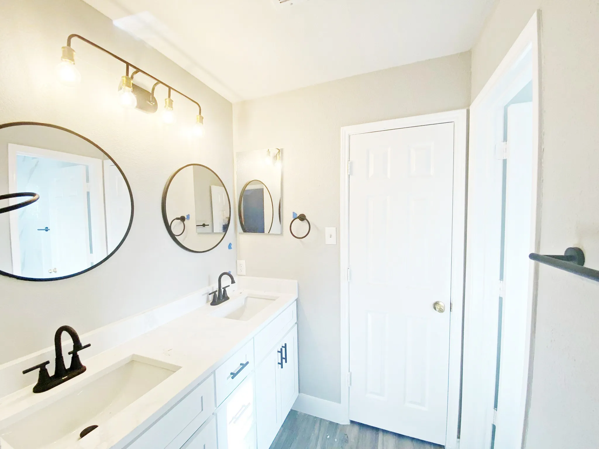 Bathroom featuring double sink vanity and wood-type flooring