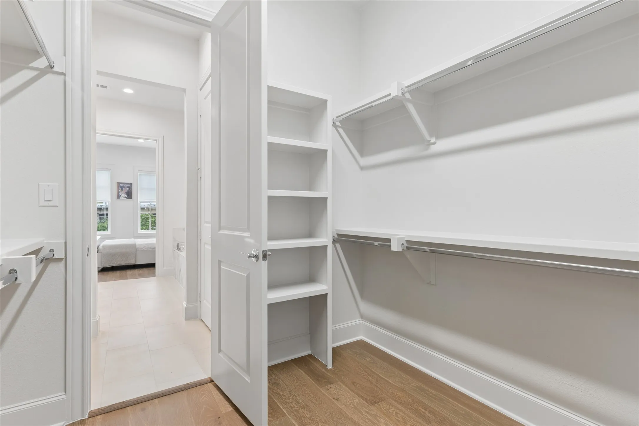 Primary bedroom offers a huge walk-in closet. Image of model home with similar layout.