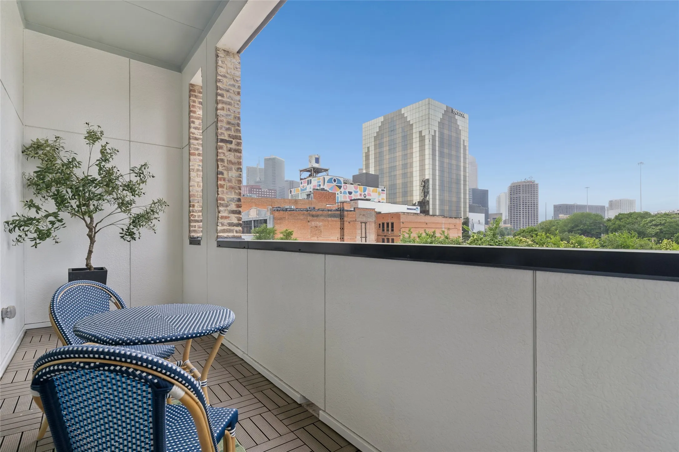 Private balcony off the main living area offers views of the Dallas skyline. Image of model home with similar layout.