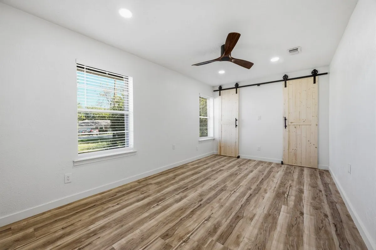 View from living room to front door with bedroom hallway to the right