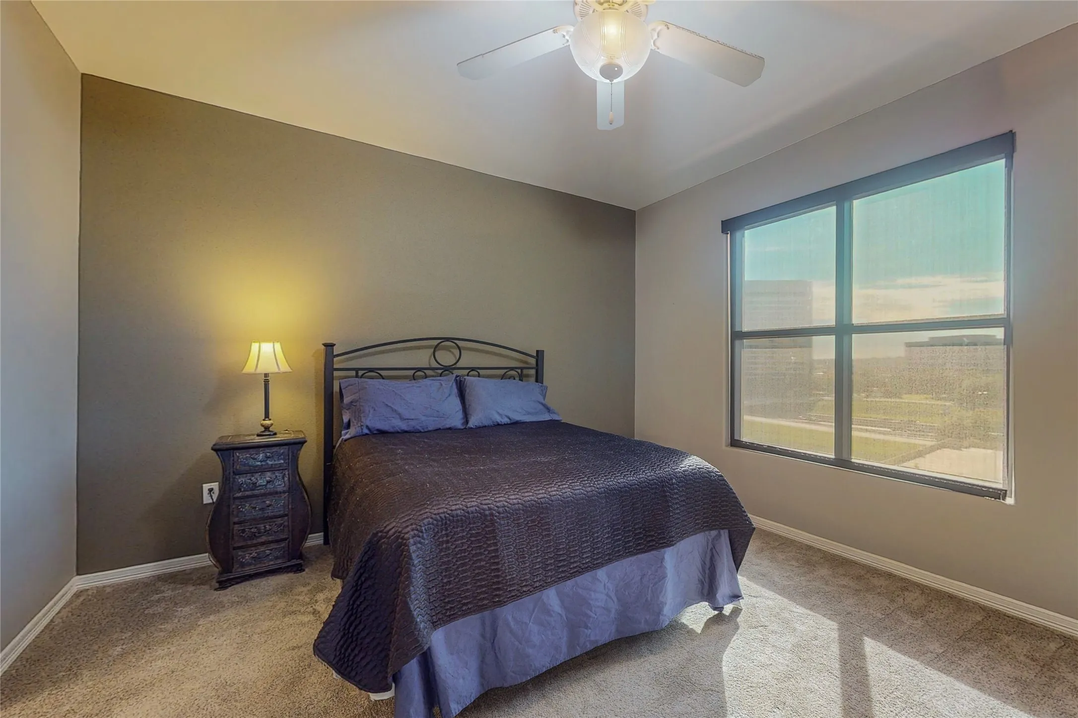 Carpeted bedroom featuring ceiling fan