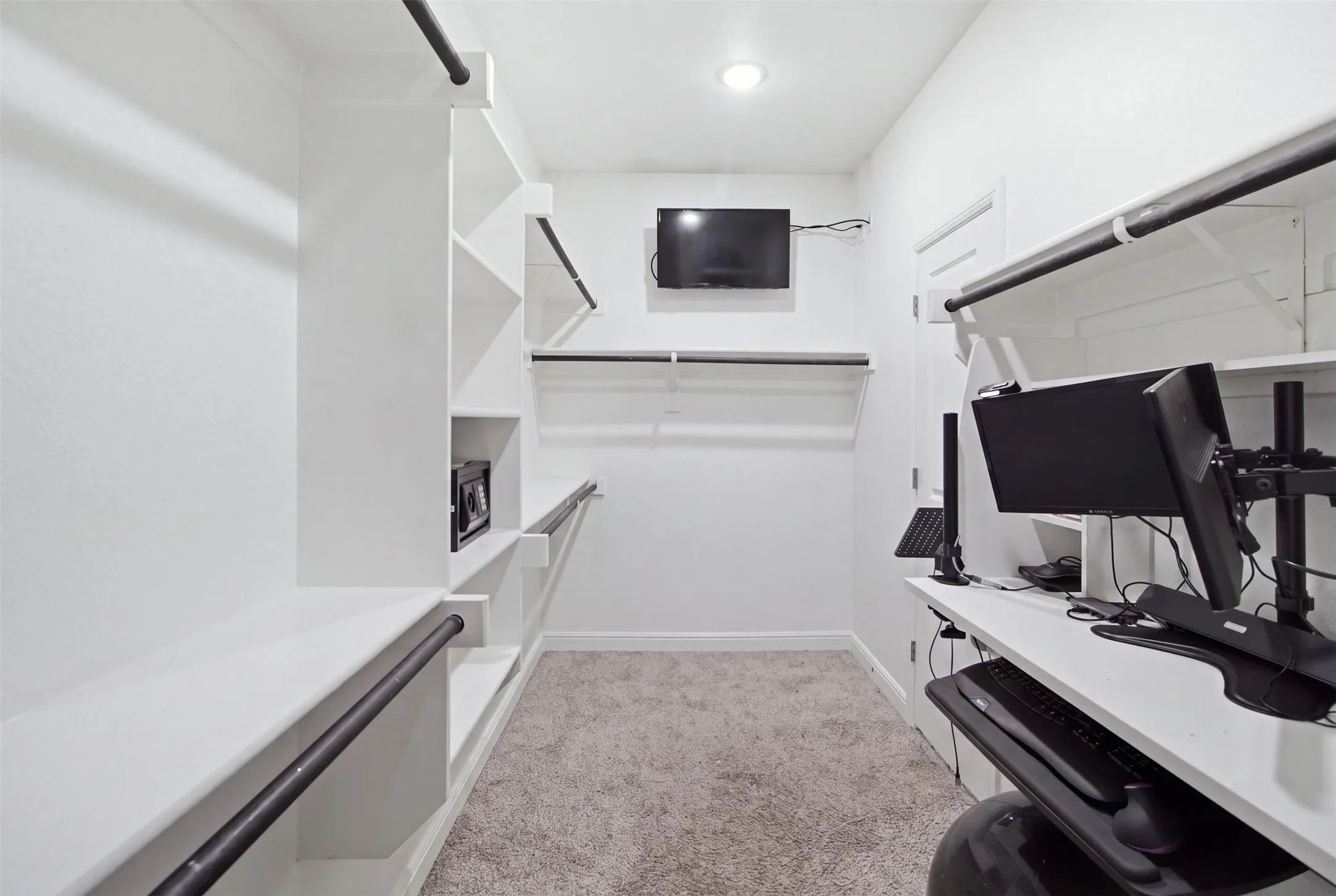 Built-in shelving, integrated hanging rods, recessed lighting, and carpet flooring