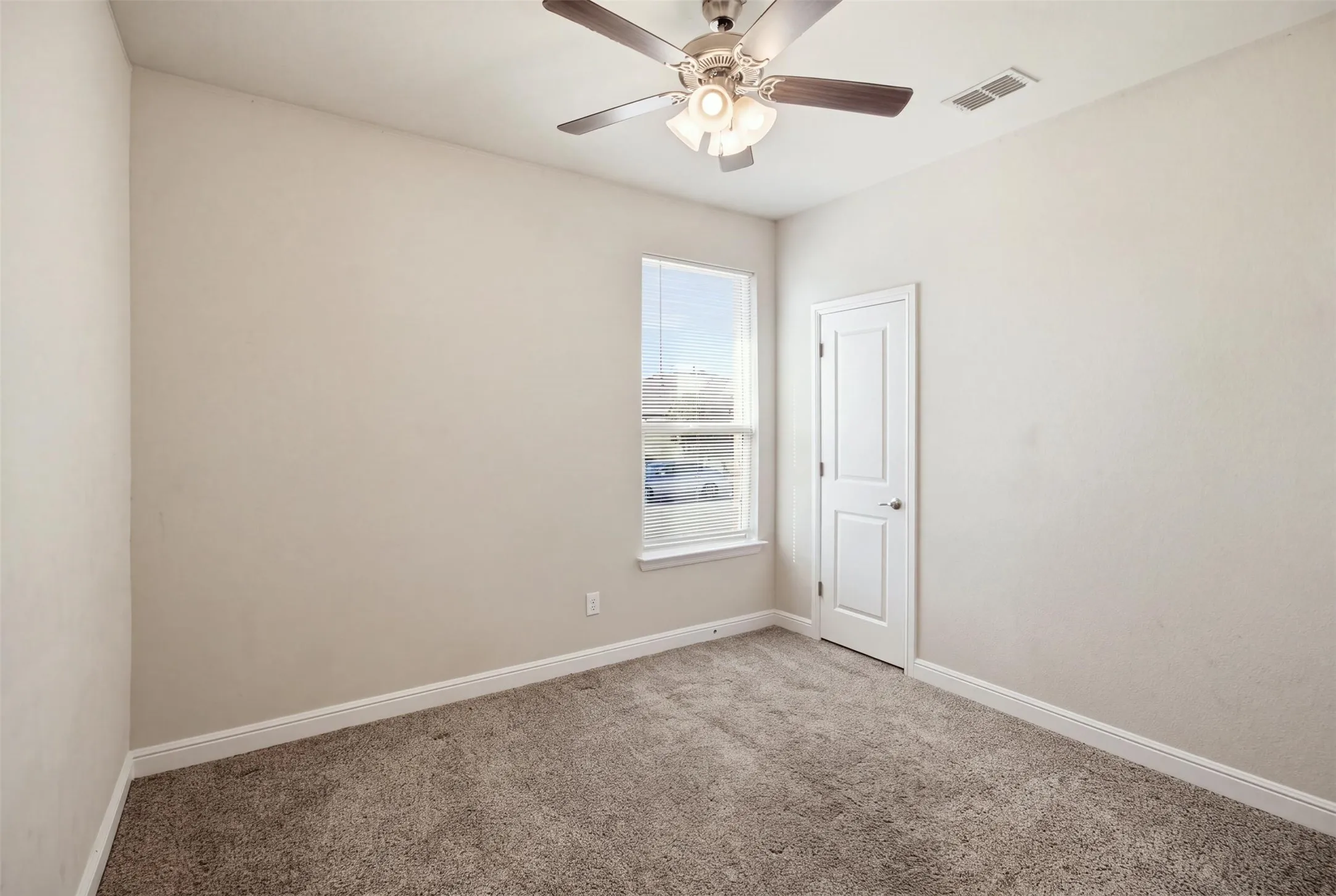 Neutral wall finishes, recessed window, ceiling fan with integrated lighting, paneled door, and carpeted flooring