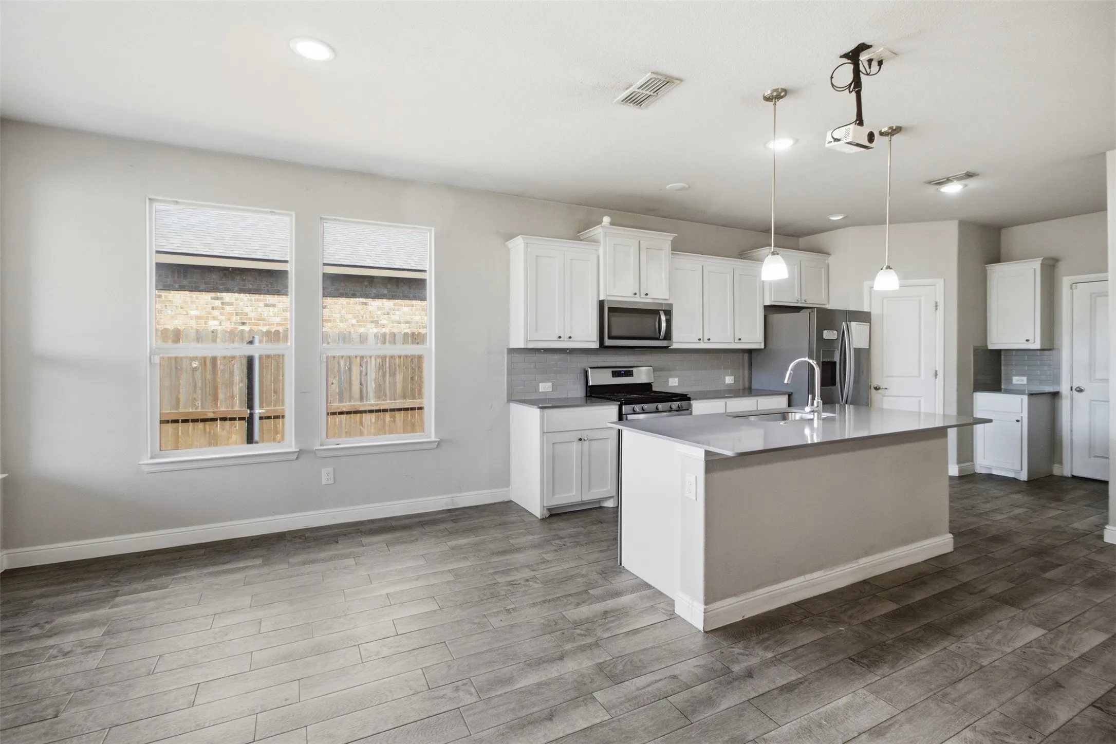 Open concept kitchen with a central island, stainless steel appliances, and white cabinetry
