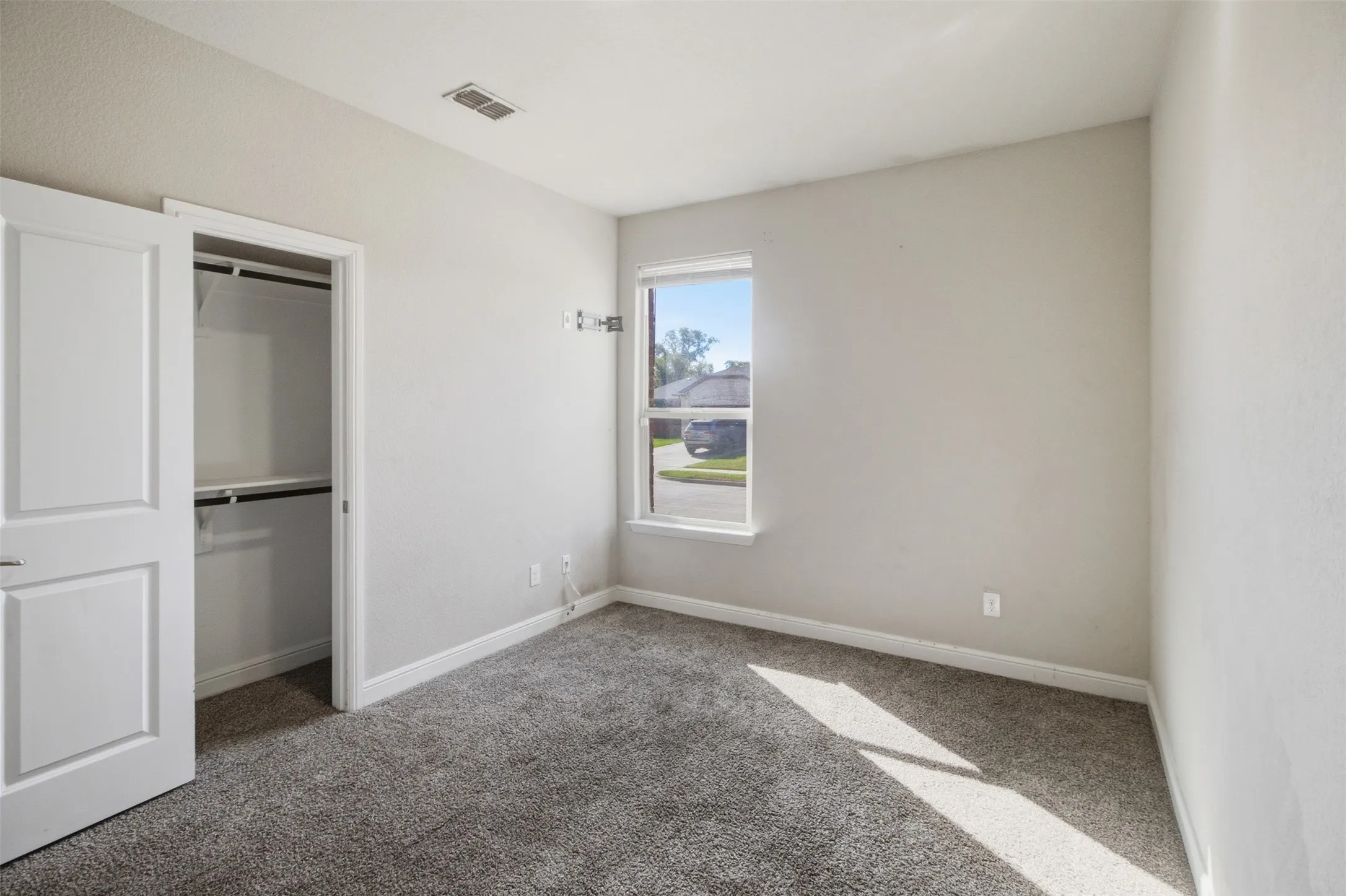 Wall-to-wall carpeting with built-in closet featuring bi-fold doors and shelving
