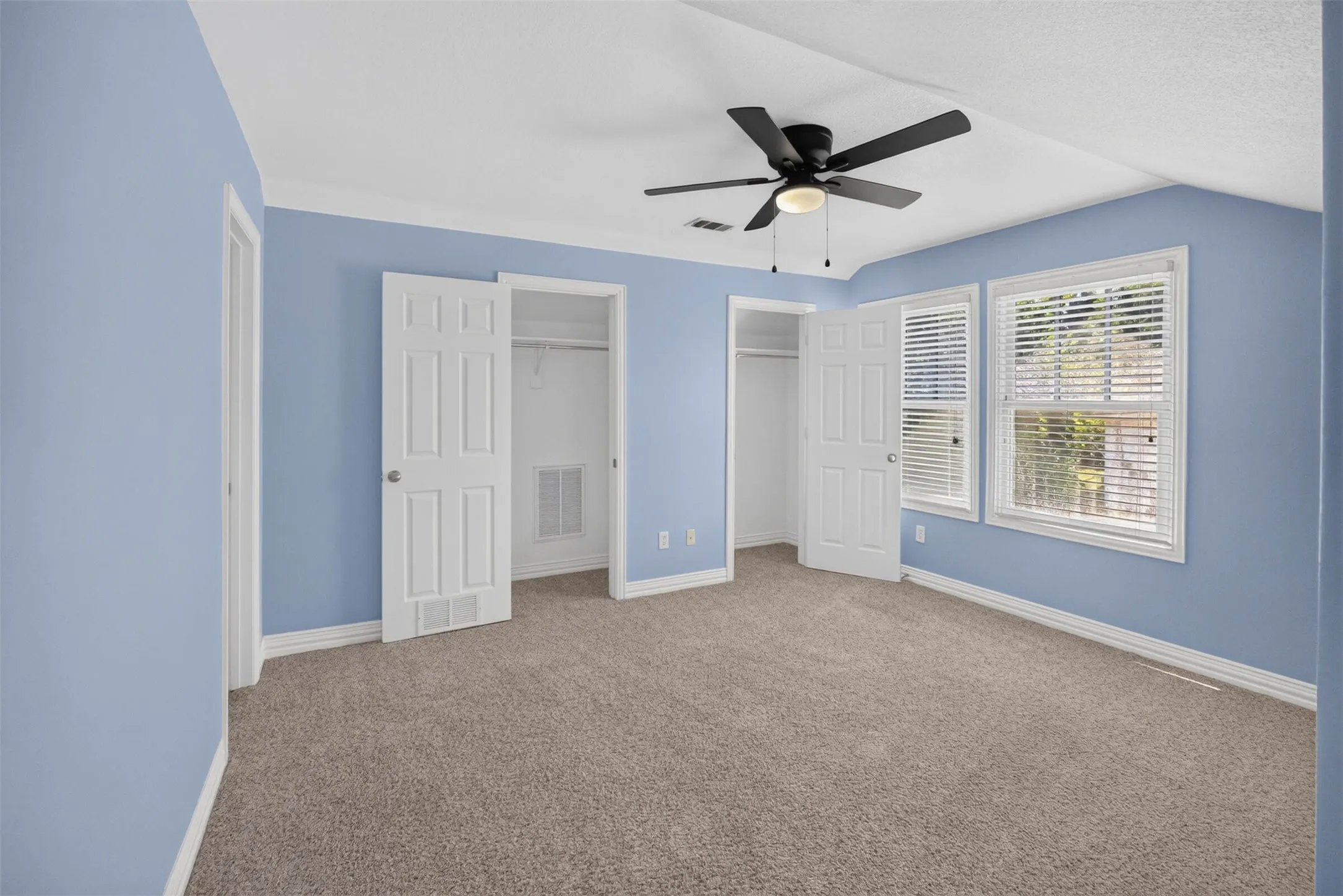 Recessed windows, crown molding, two closets with bi-fold doors, and a ceiling fan