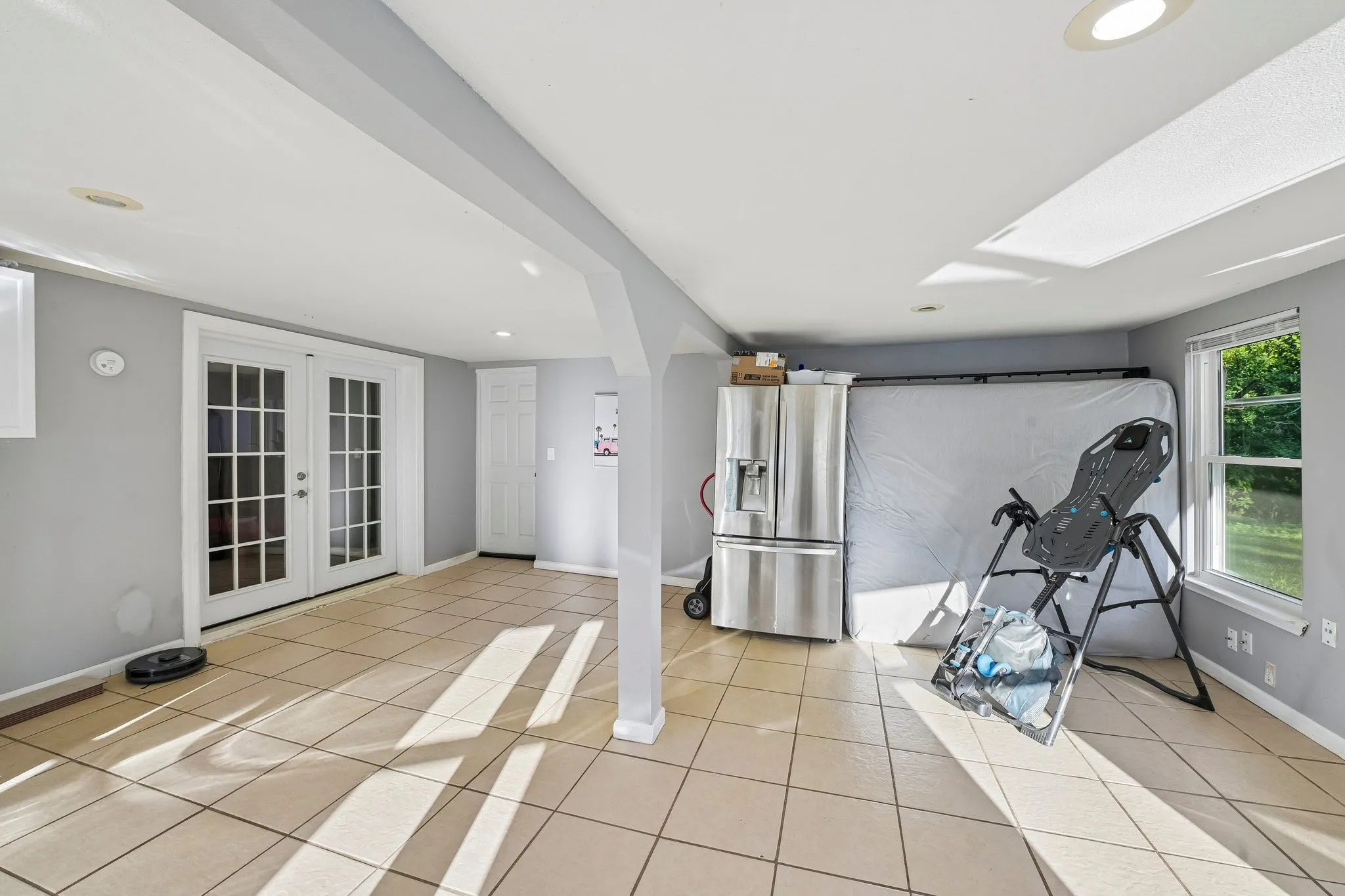 Recessed lighting, tile flooring, and white French doors