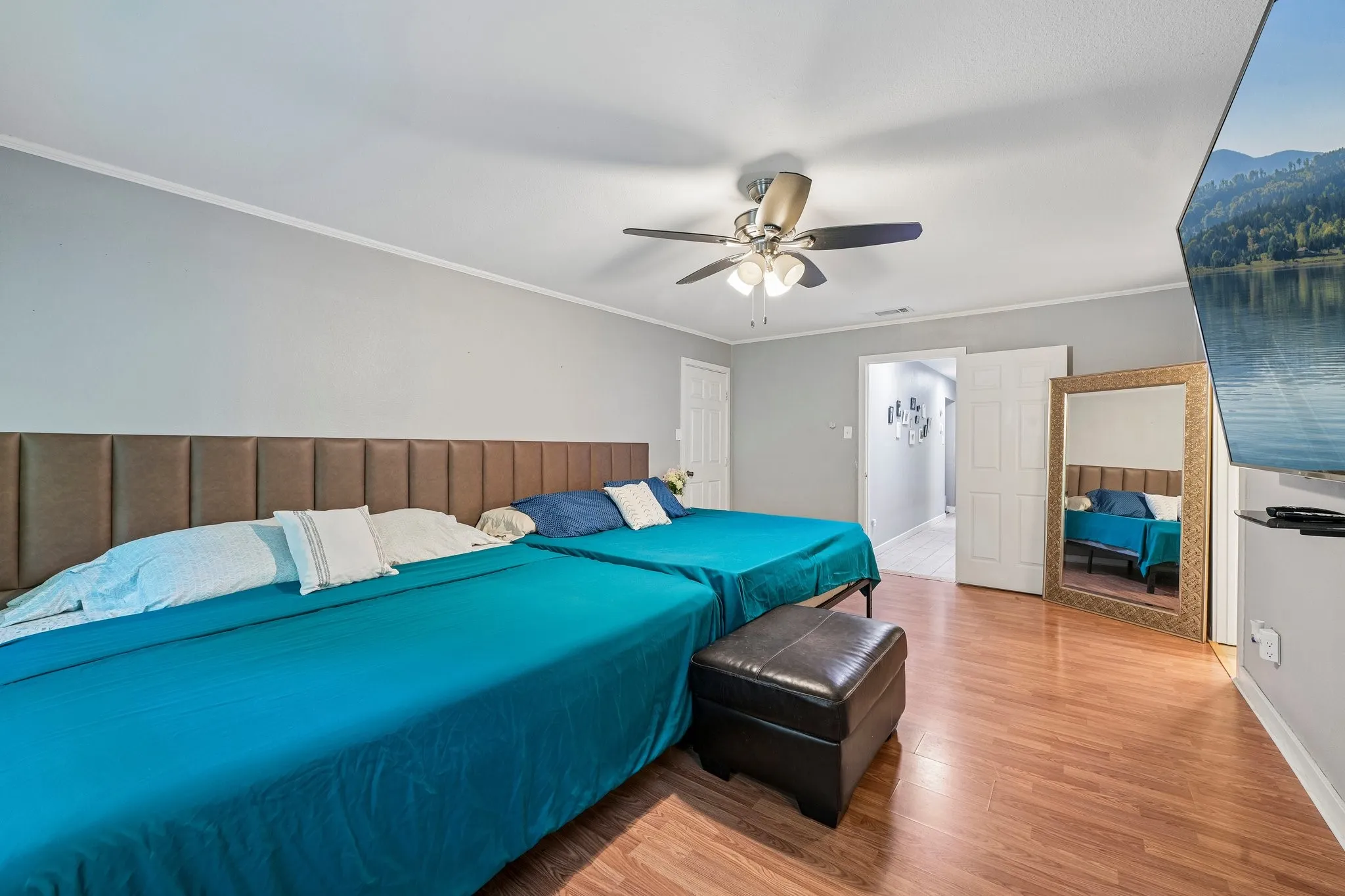 Wood-finish flooring with light gray walls, white trim, and a ceiling fan