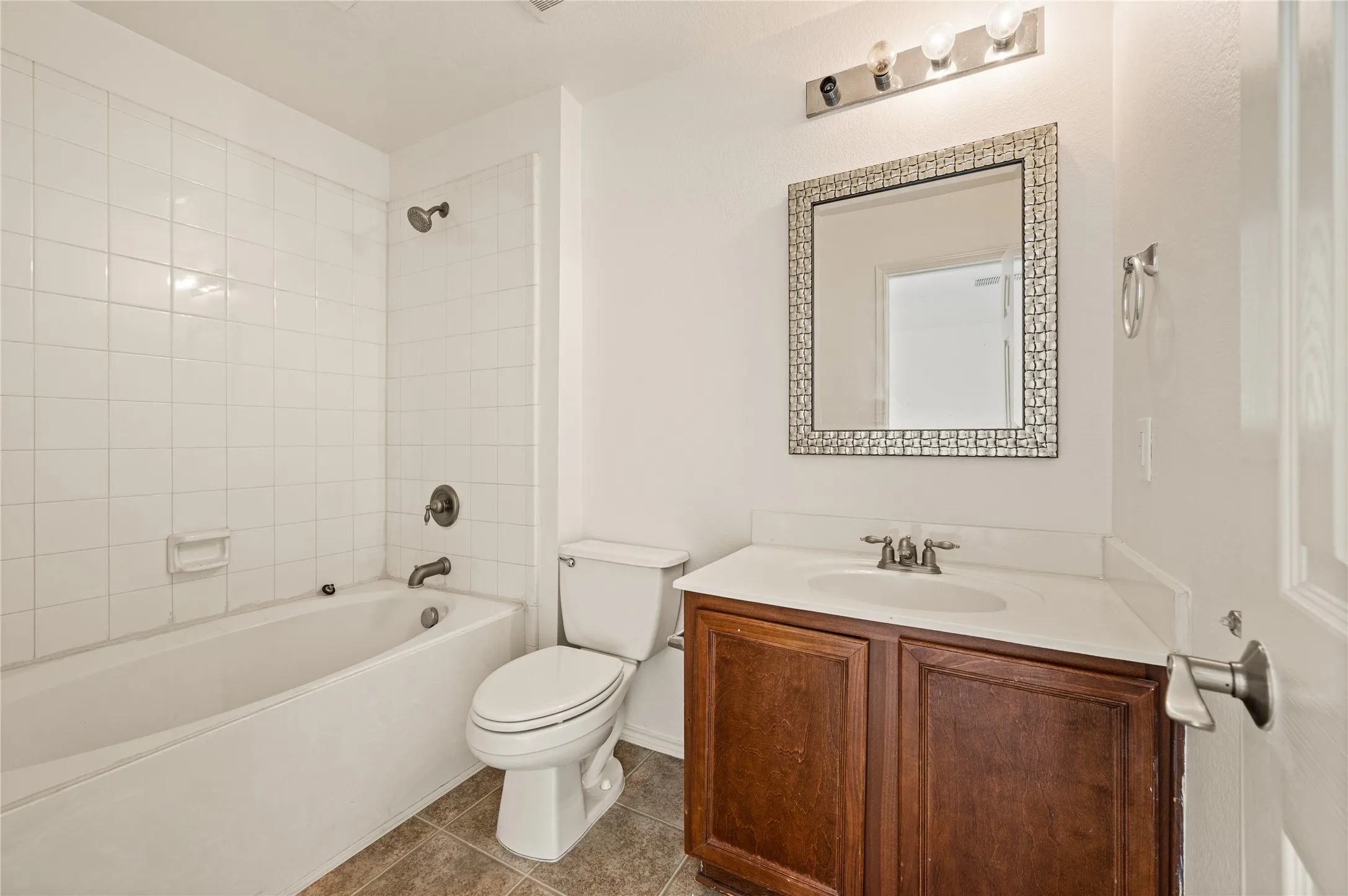 White tiled tub and shower combination with oil-rubbed bronze fixtures