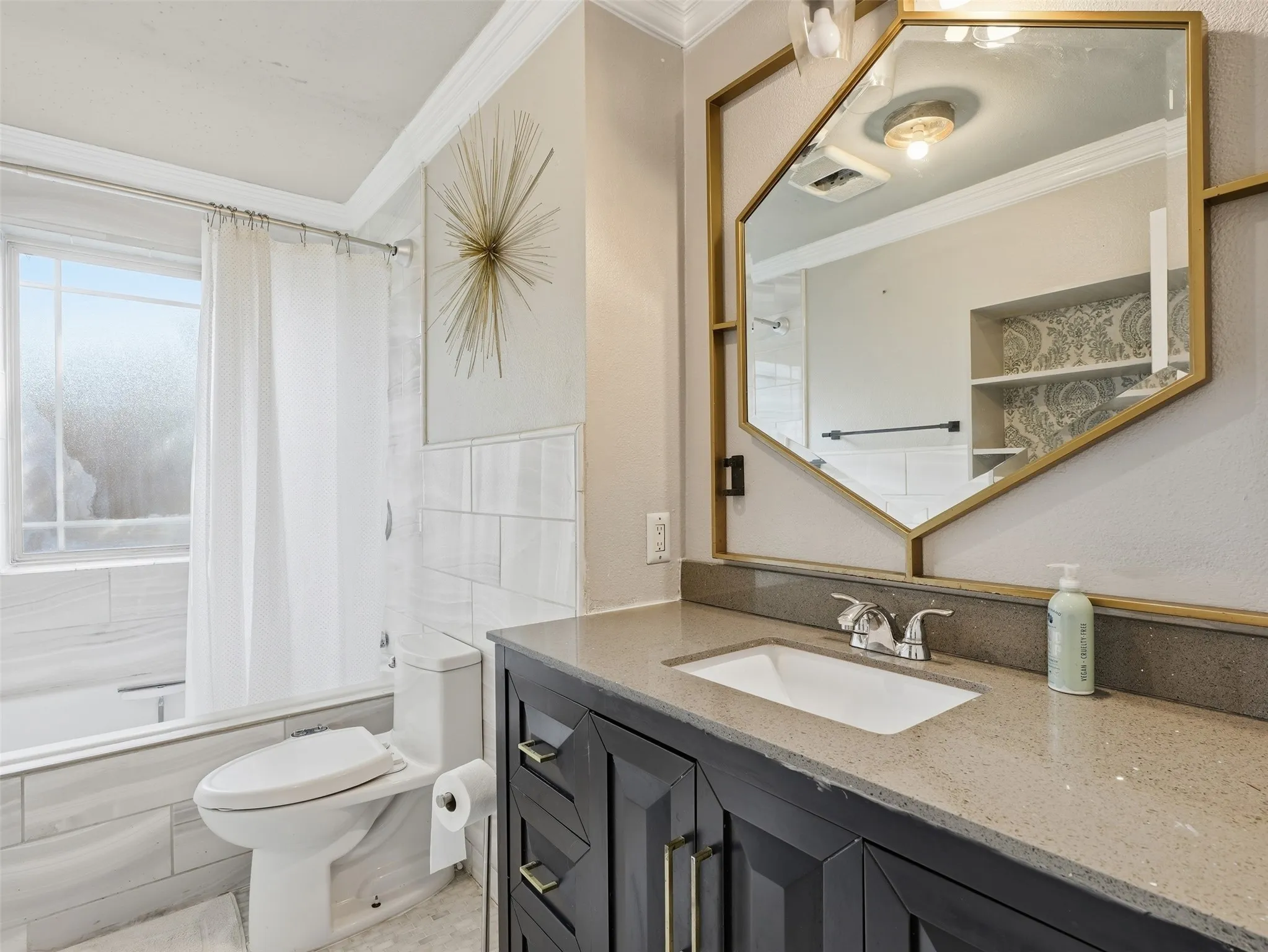 Vanity with a light-toned countertop, under-mount sink, and dark cabinetry