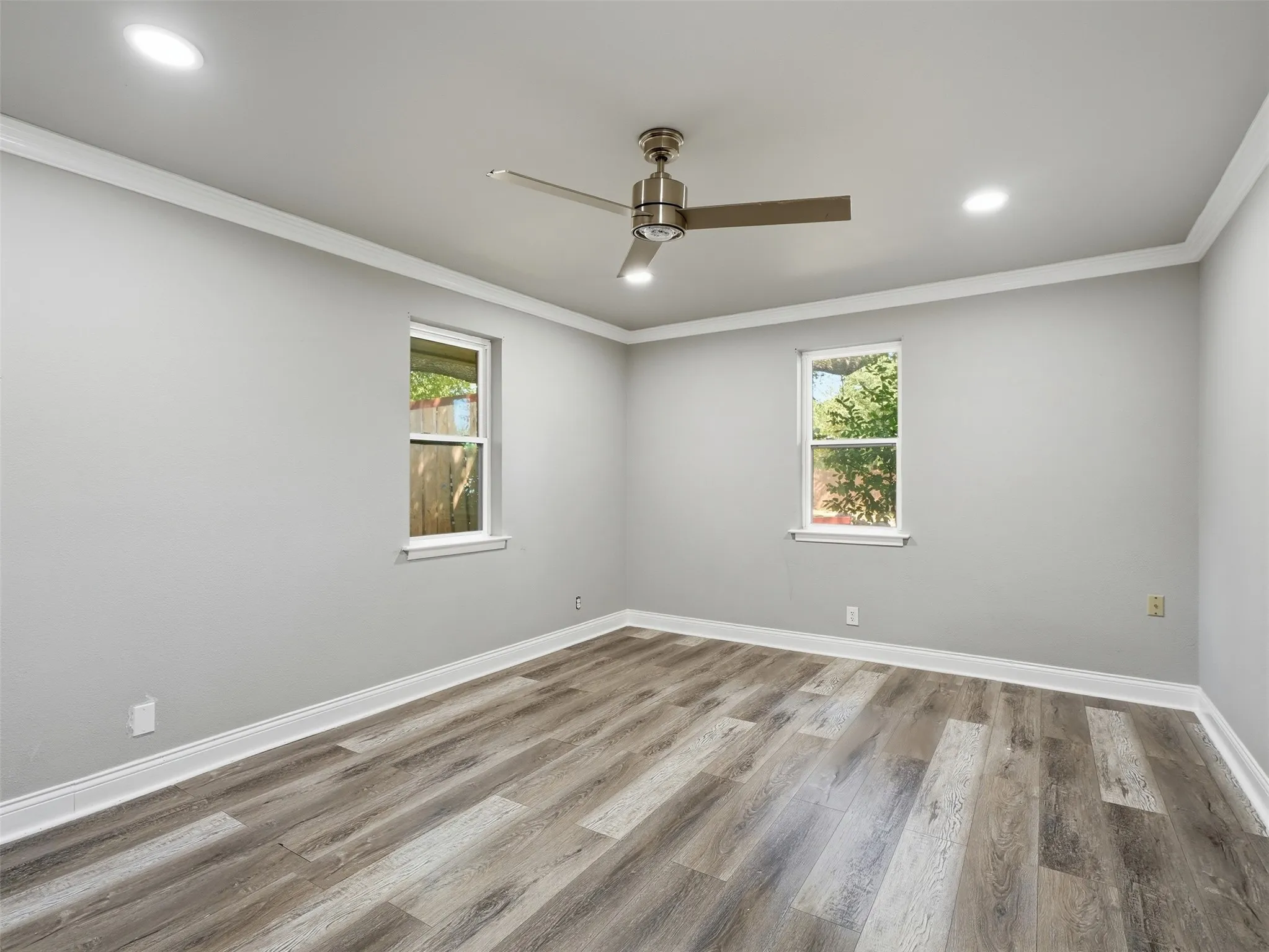 Wood-finish flooring, recessed lighting, crown molding, and a ceiling fan with light fixture
