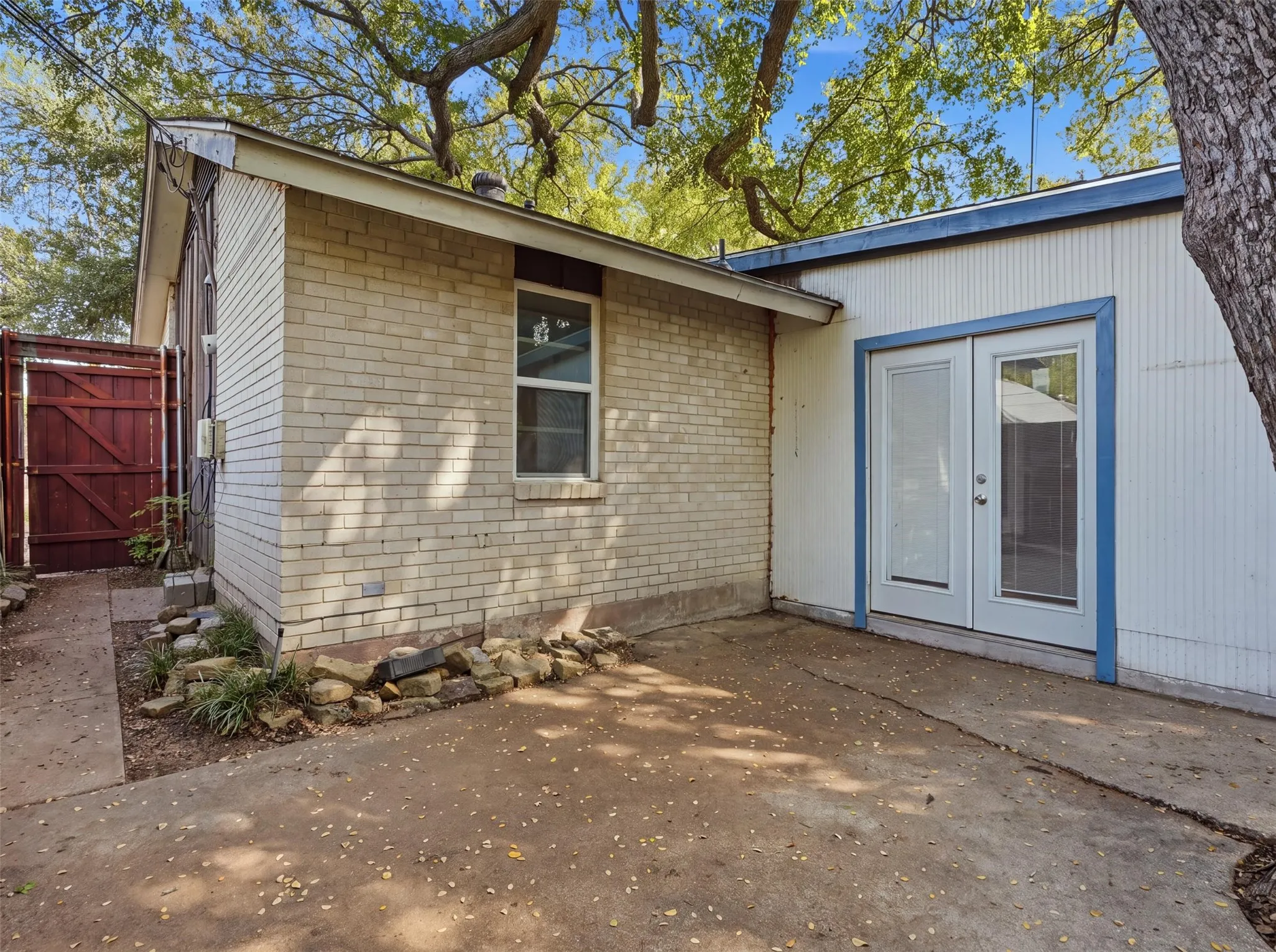 Brick and panel siding exterior with a concrete patio