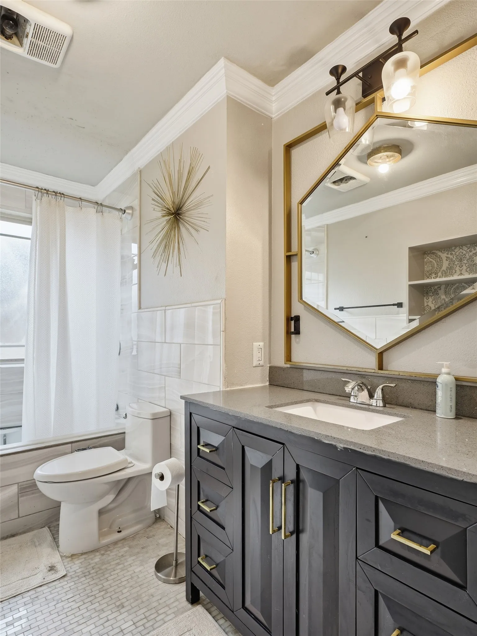 Dark wood-finish vanity with gold-tone hardware, rectangular undermount sink, and a stone countertop