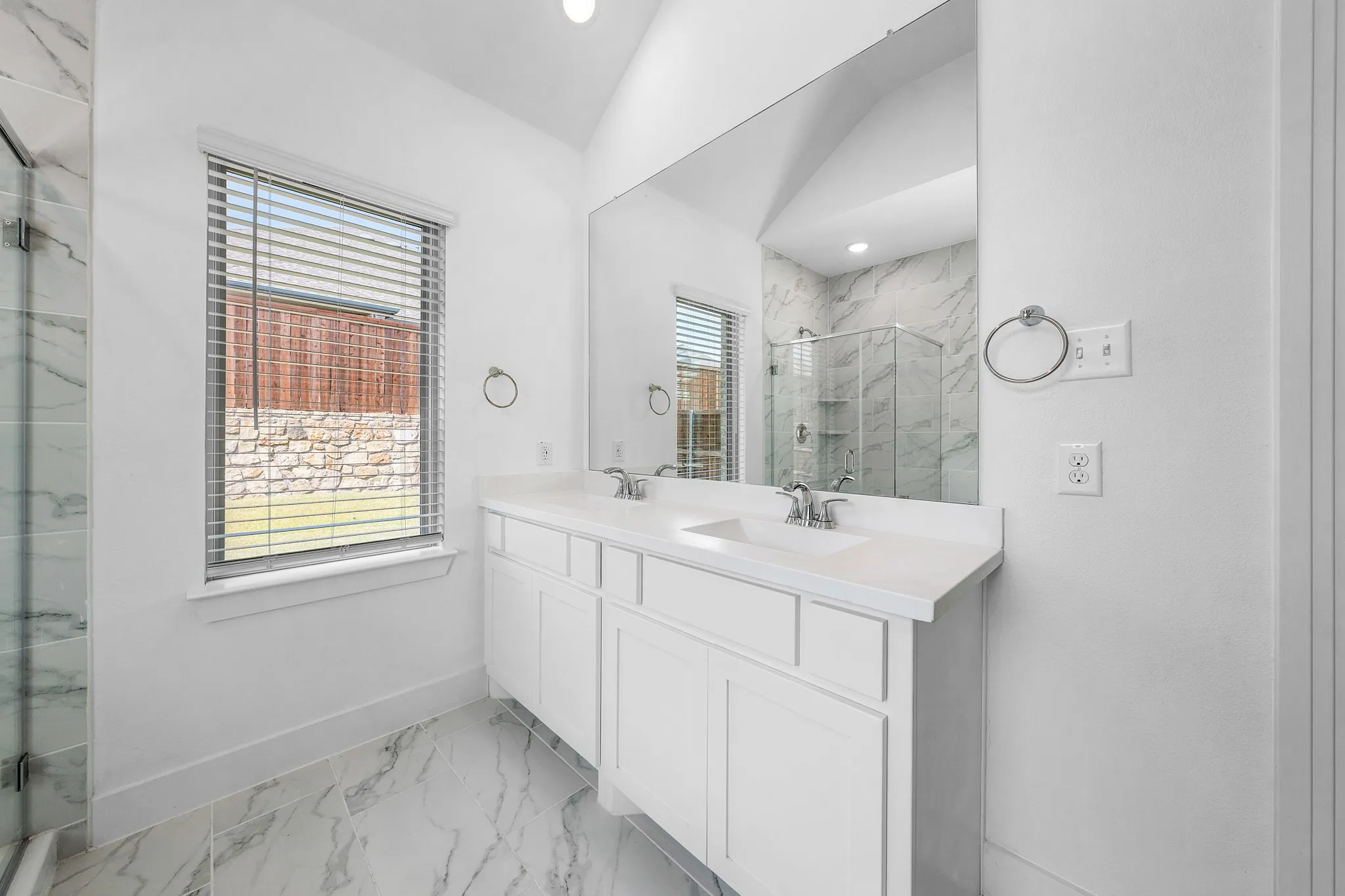 Dual vanity with white cabinetry, integrated sinks, and polished chrome fixtures