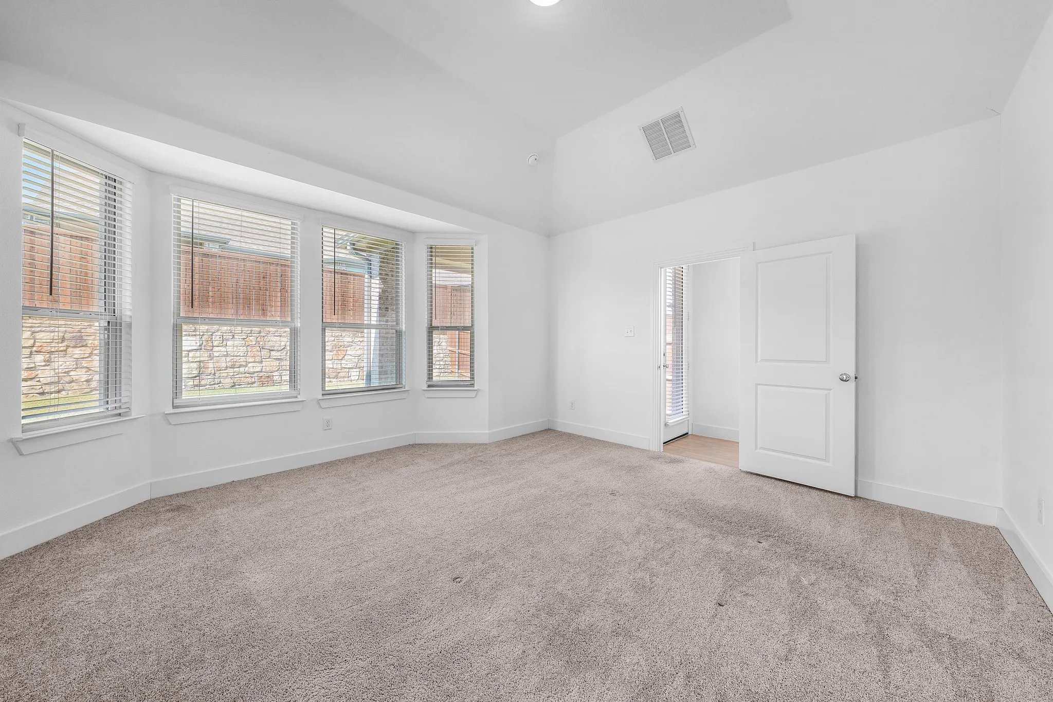 Spacious interior with neutral carpet flooring and white painted walls