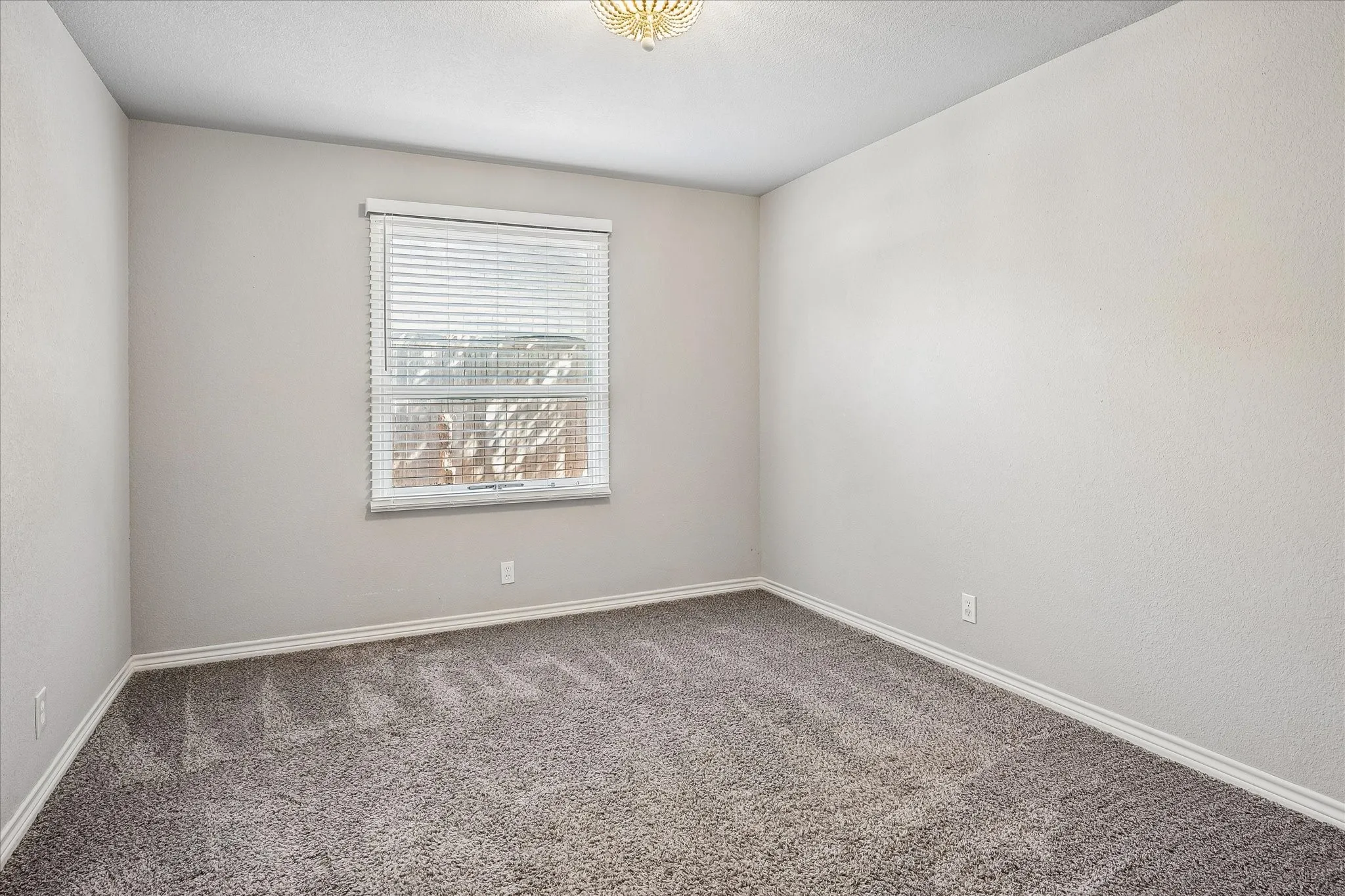 Neutral wall color, wall-to-wall carpeting, window with blinds, and flush mount ceiling light