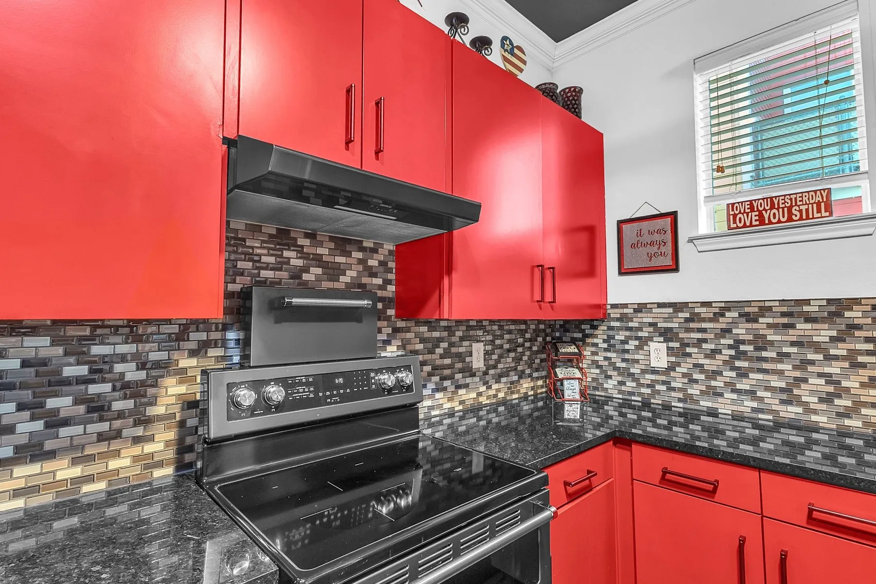 Kitchen with stainless range, vent hood, granite countertops and tile backsplash
