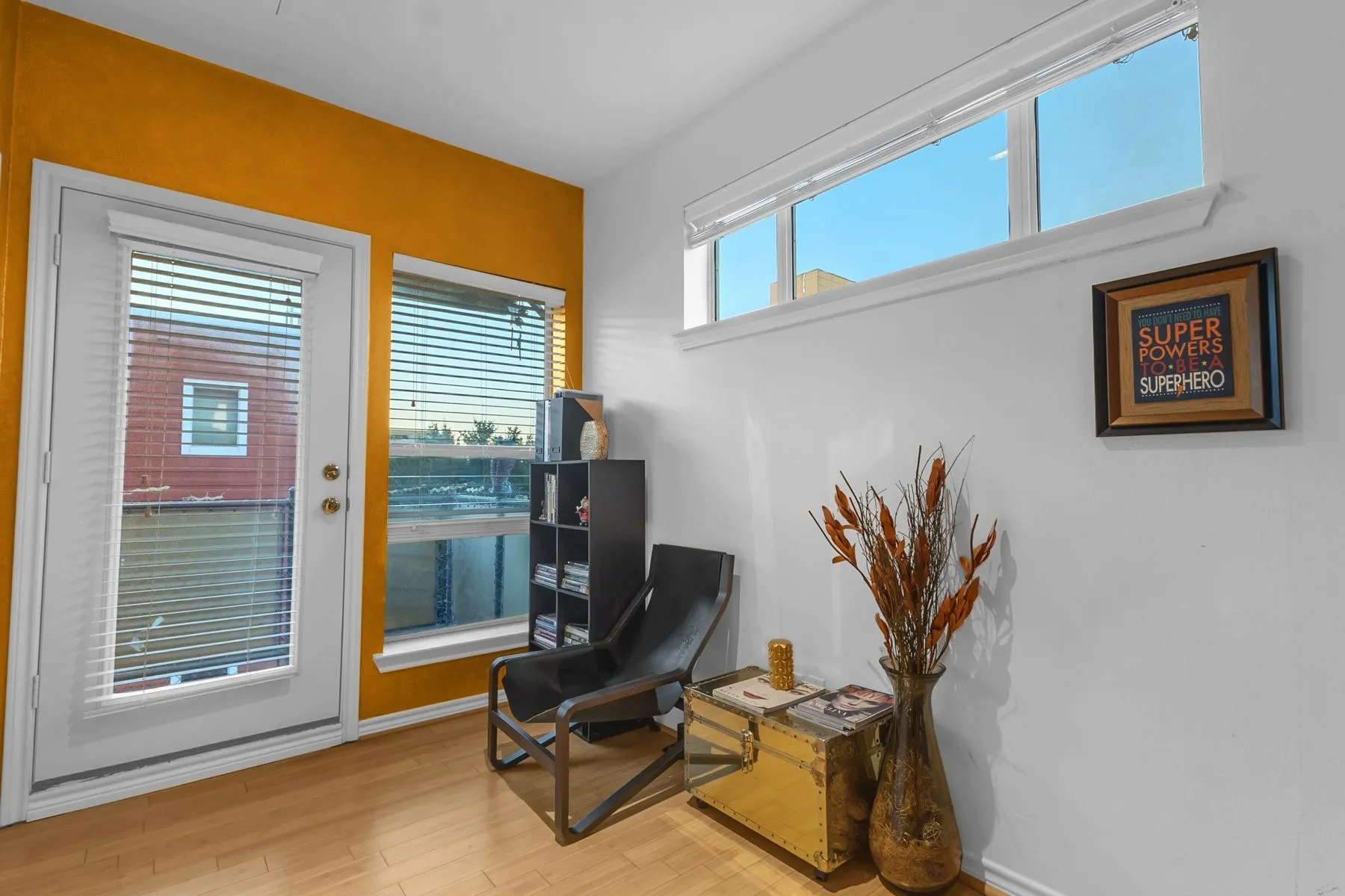 Primary suite sitting area with a door to the balcony and clerestory windows