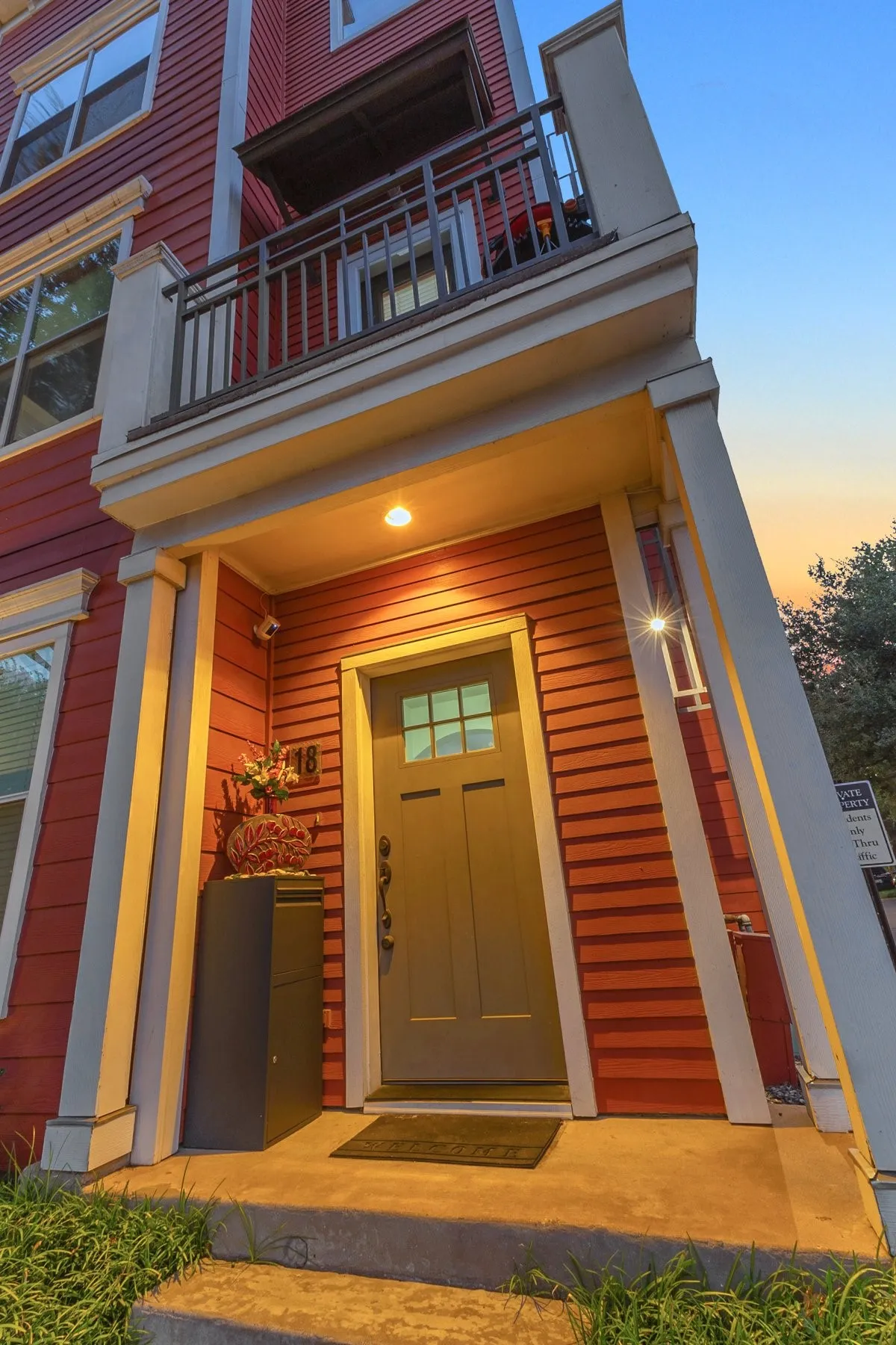 Covered front entry with a craftsman-style door and porch lighting