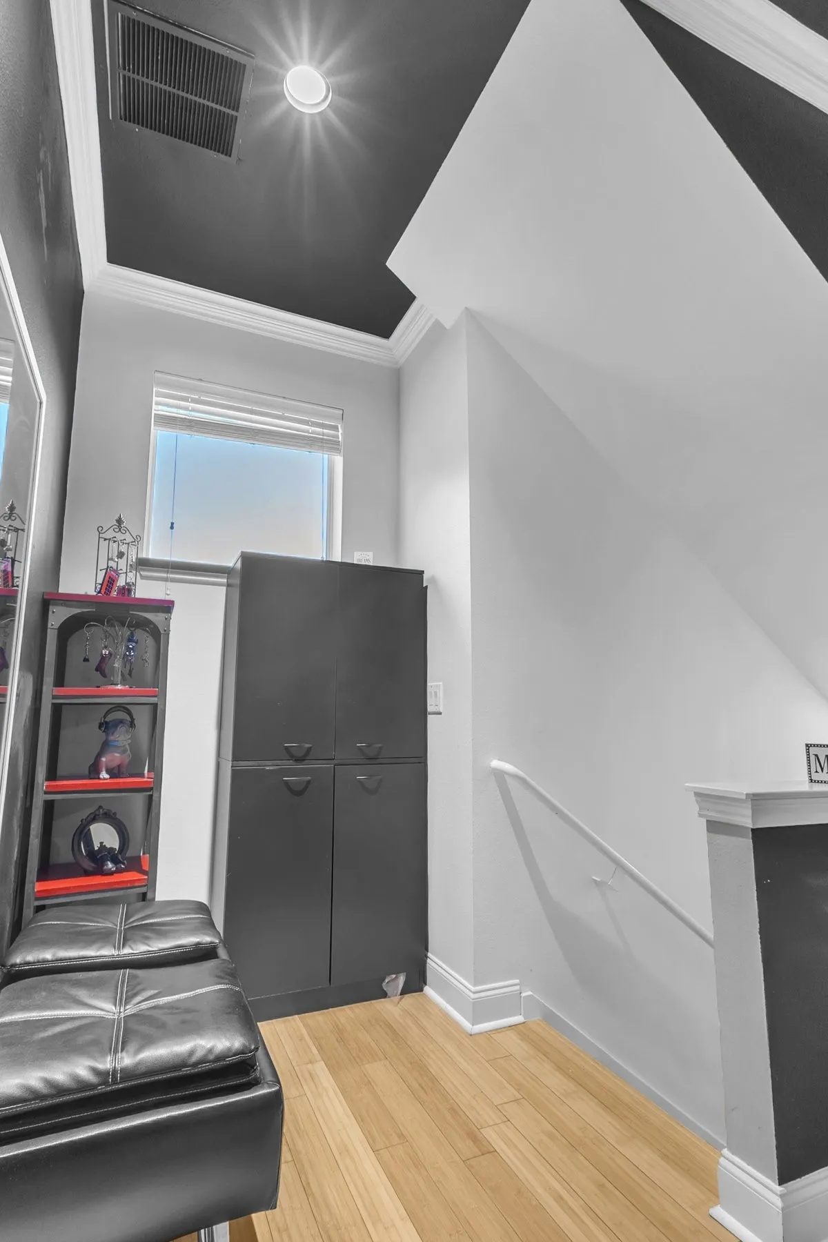 Hallway landing with a window, crown molding and built-in storage space