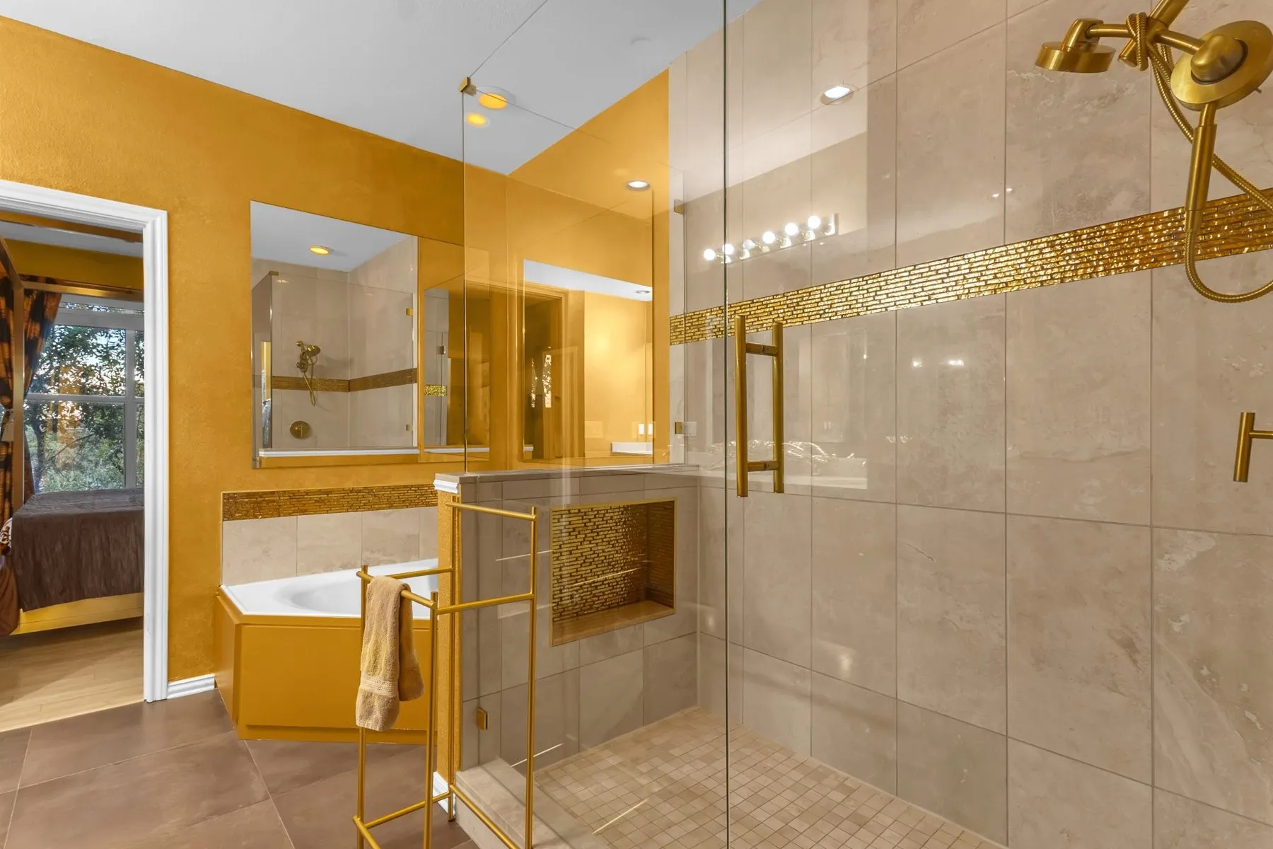 Primary bath with a soaking tub, built-in niche and frameless glass shower