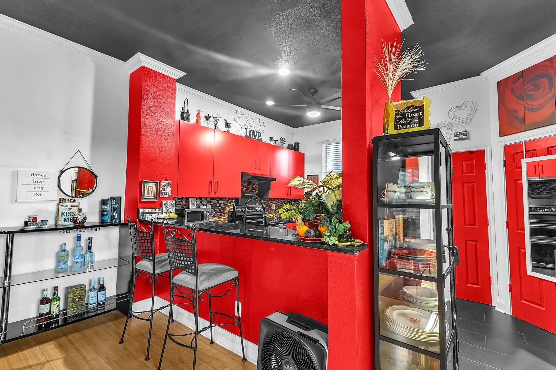 Breakfast bar seating with display shelving beside the kitchen