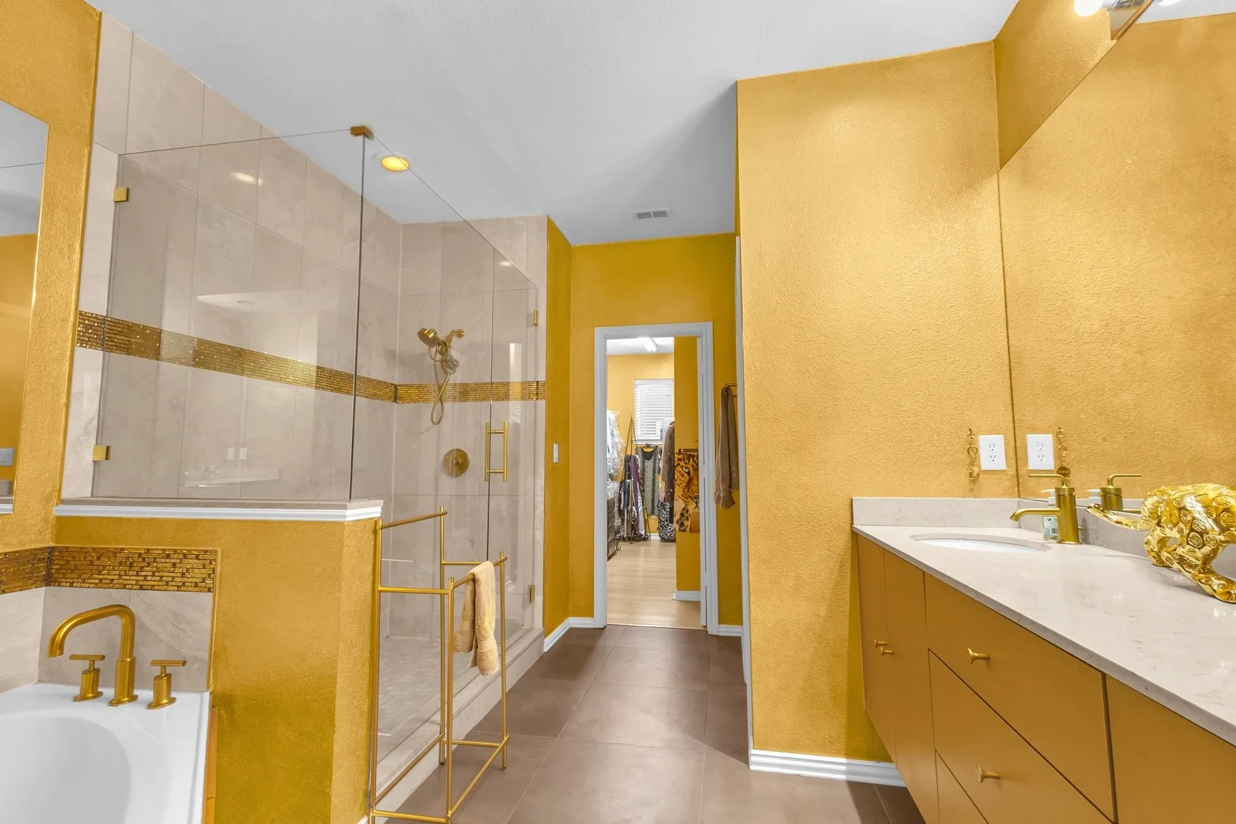 Primary bath with a dual vanity leading to the walk-in closet