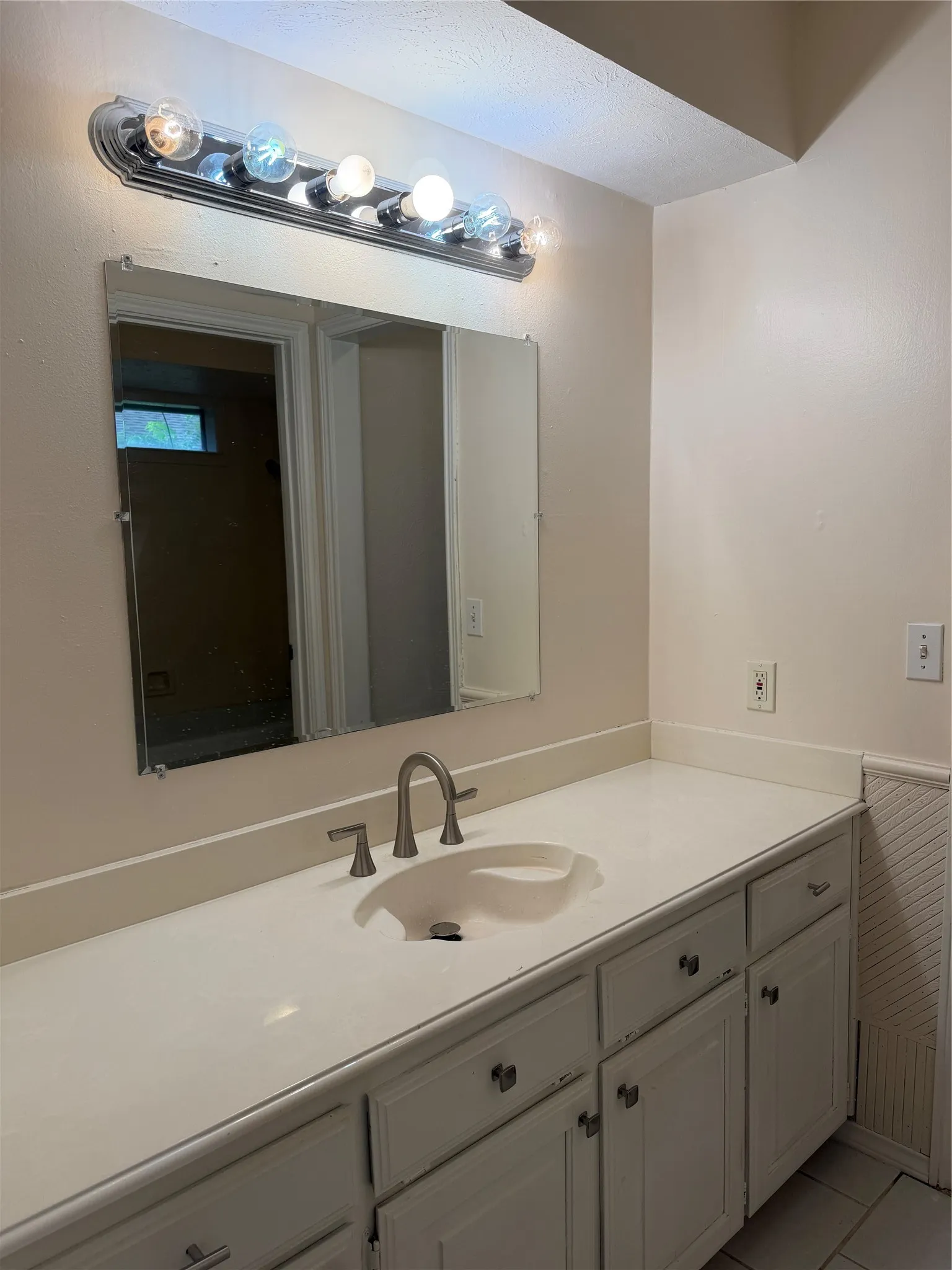 Vanity with an integrated sink, brushed nickel faucet, and white cabinetry