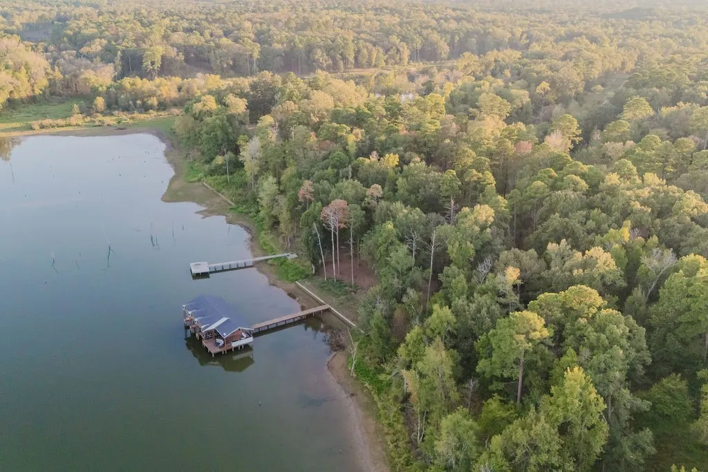 Waterfront property featuring a private boat house, two private docks, and mature tree coverage