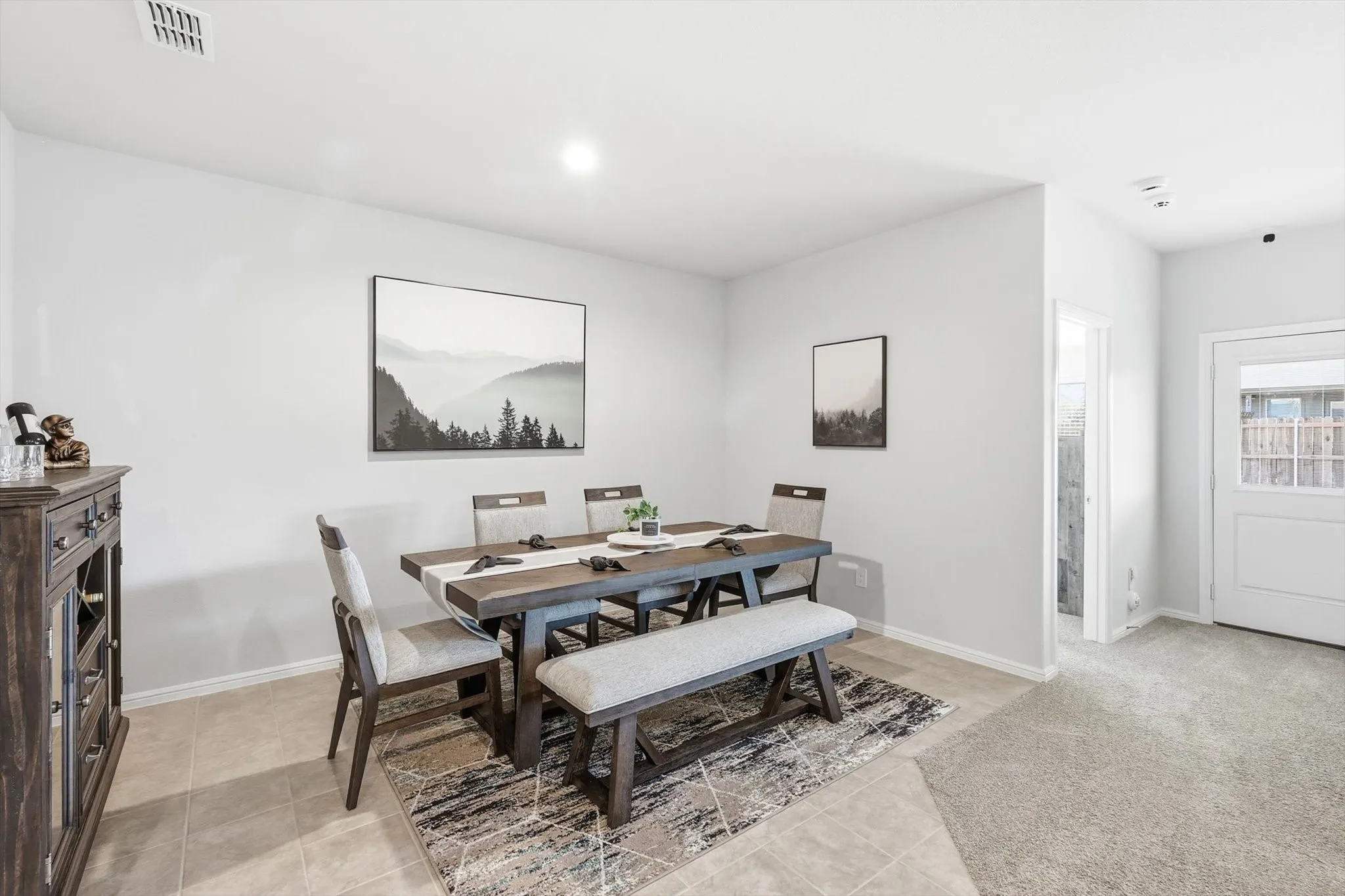 Recessed lighting illuminates the dining area featuring neutral wall tones and tile flooring