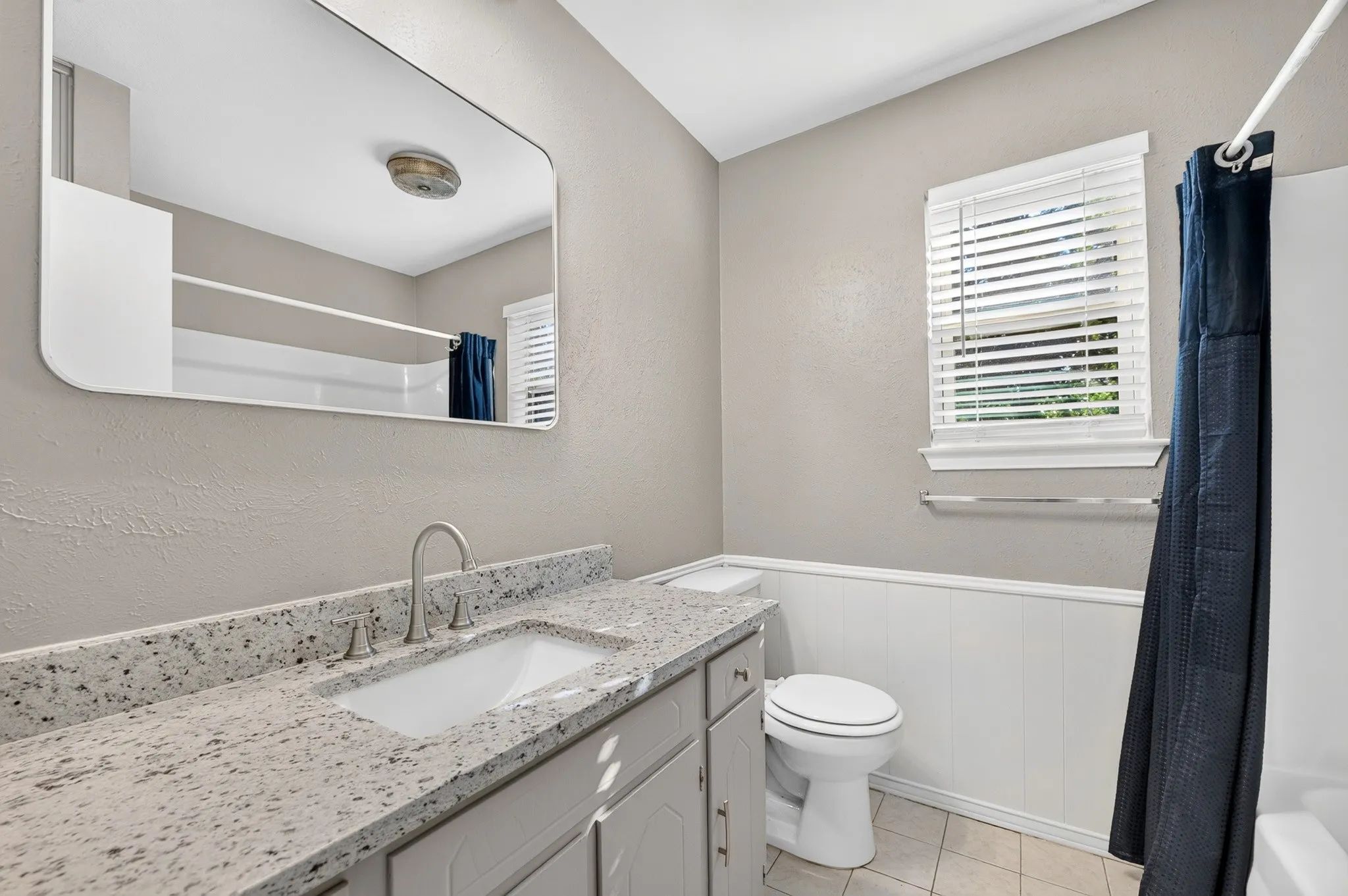 Vanity with a light-toned countertop, undermount sink, and brushed nickel faucet