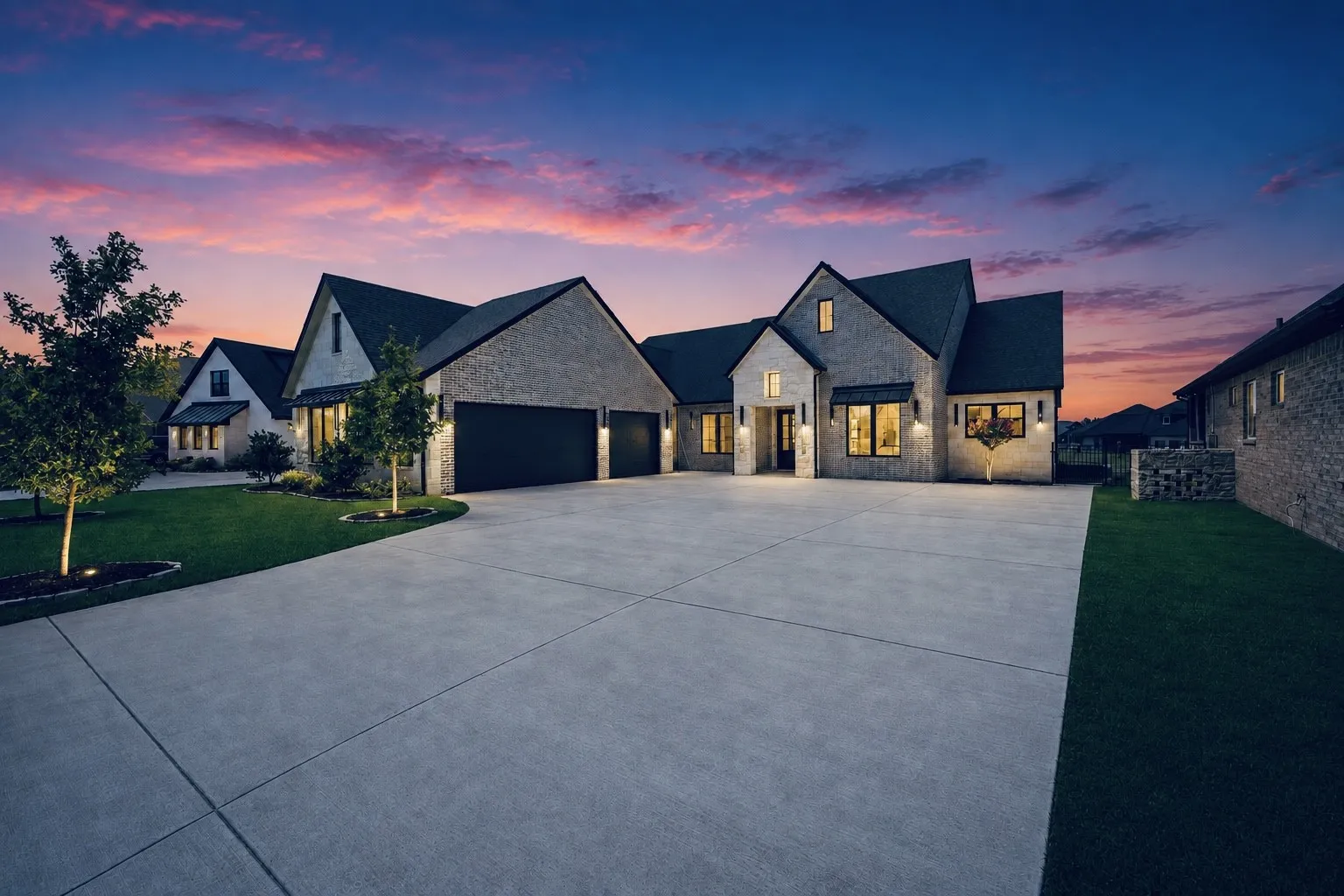 Stone façade residence featuring multiple gables, a three-car garage, and an expansive concrete driveway