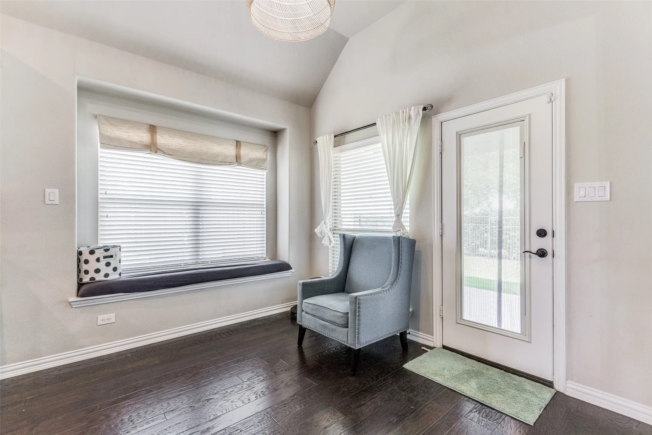 Hardwood-finish flooring, built-in window seating, recessed window, vaulted ceiling, and a full-light exterior door