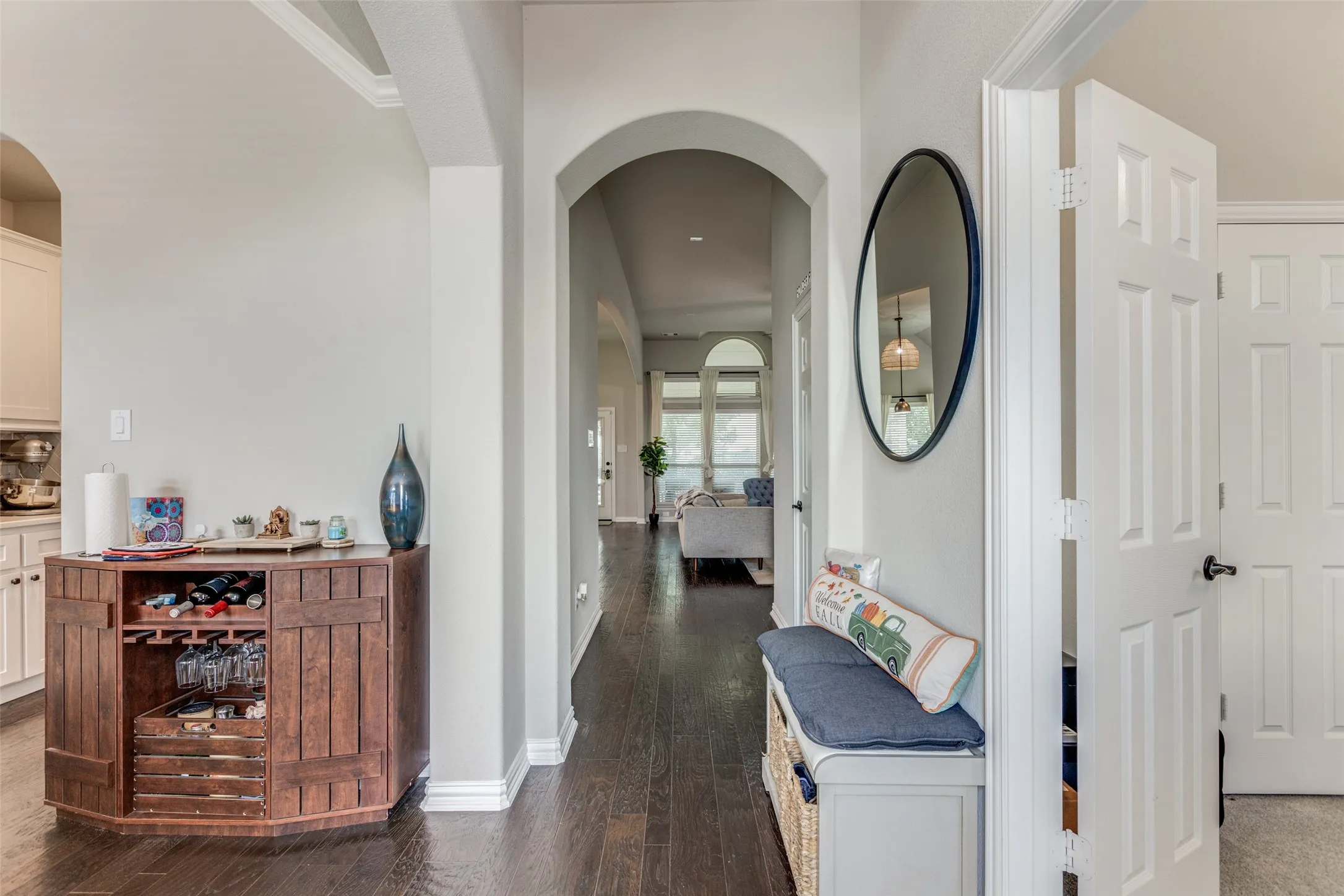 Hardwood-finish flooring, arched doorways, white interior doors, and crown molding