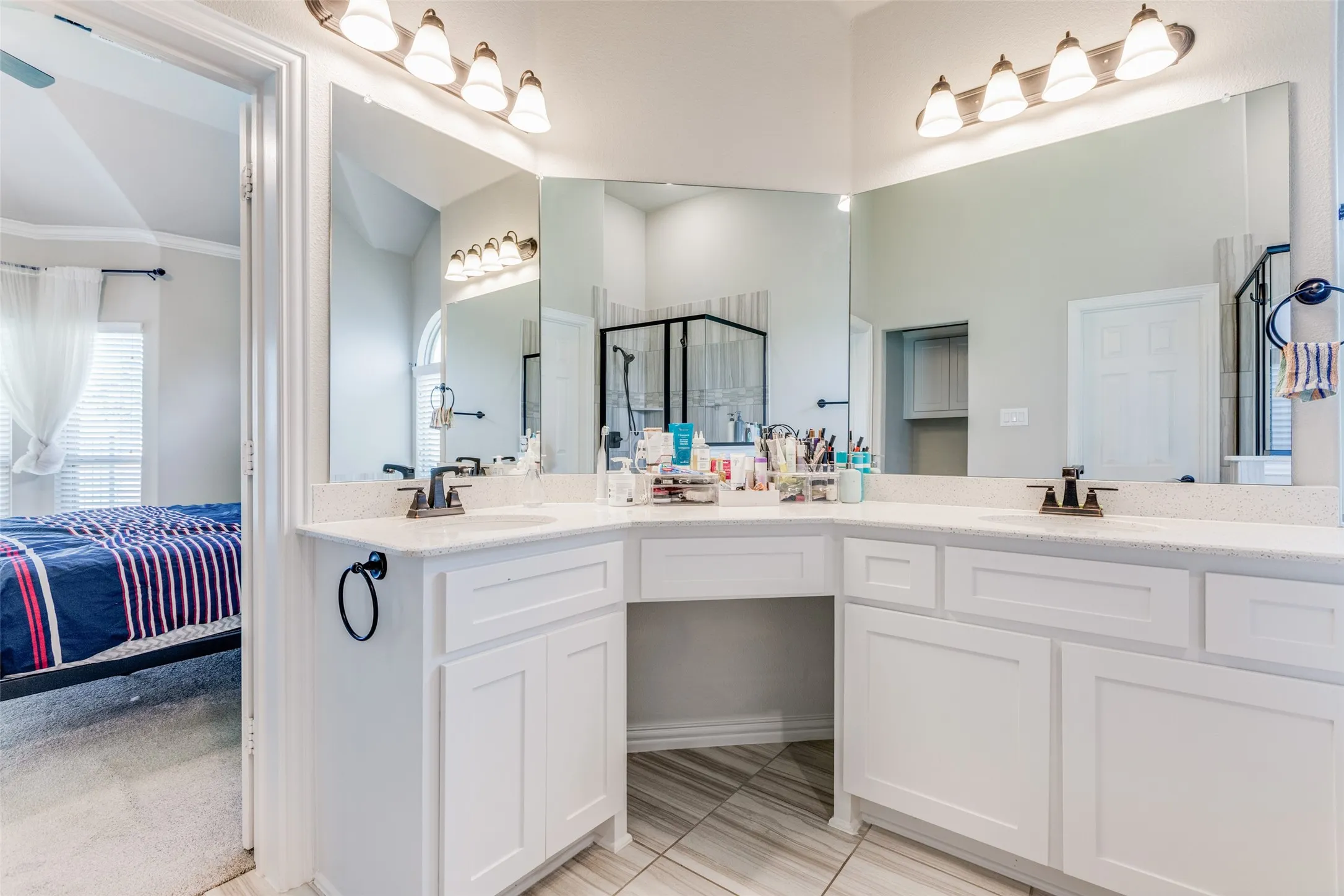 Dual sink vanity with white cabinetry, quartz-finish countertop, and tile flooring