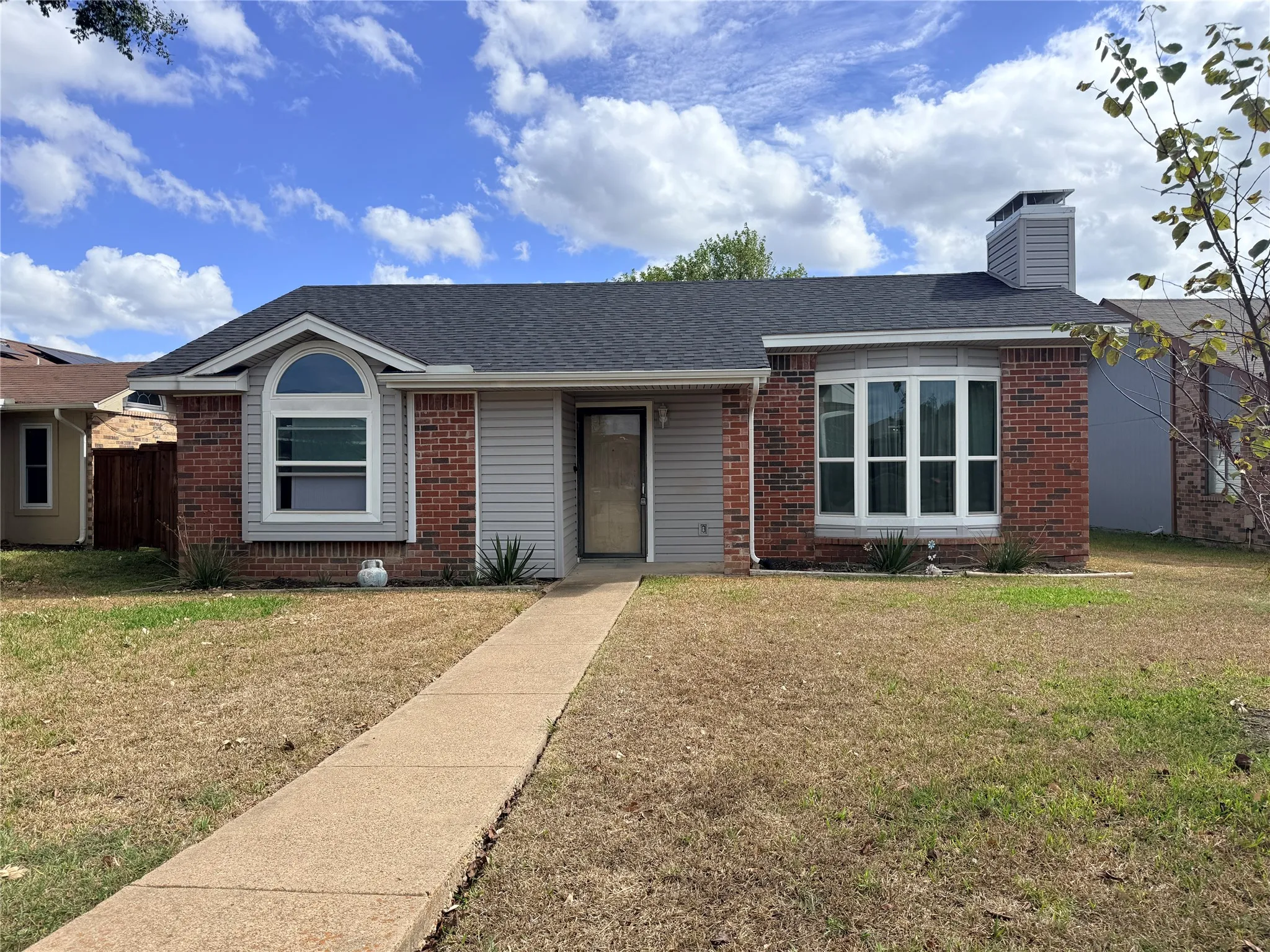 Traditional brick and siding exterior with an arched window accent