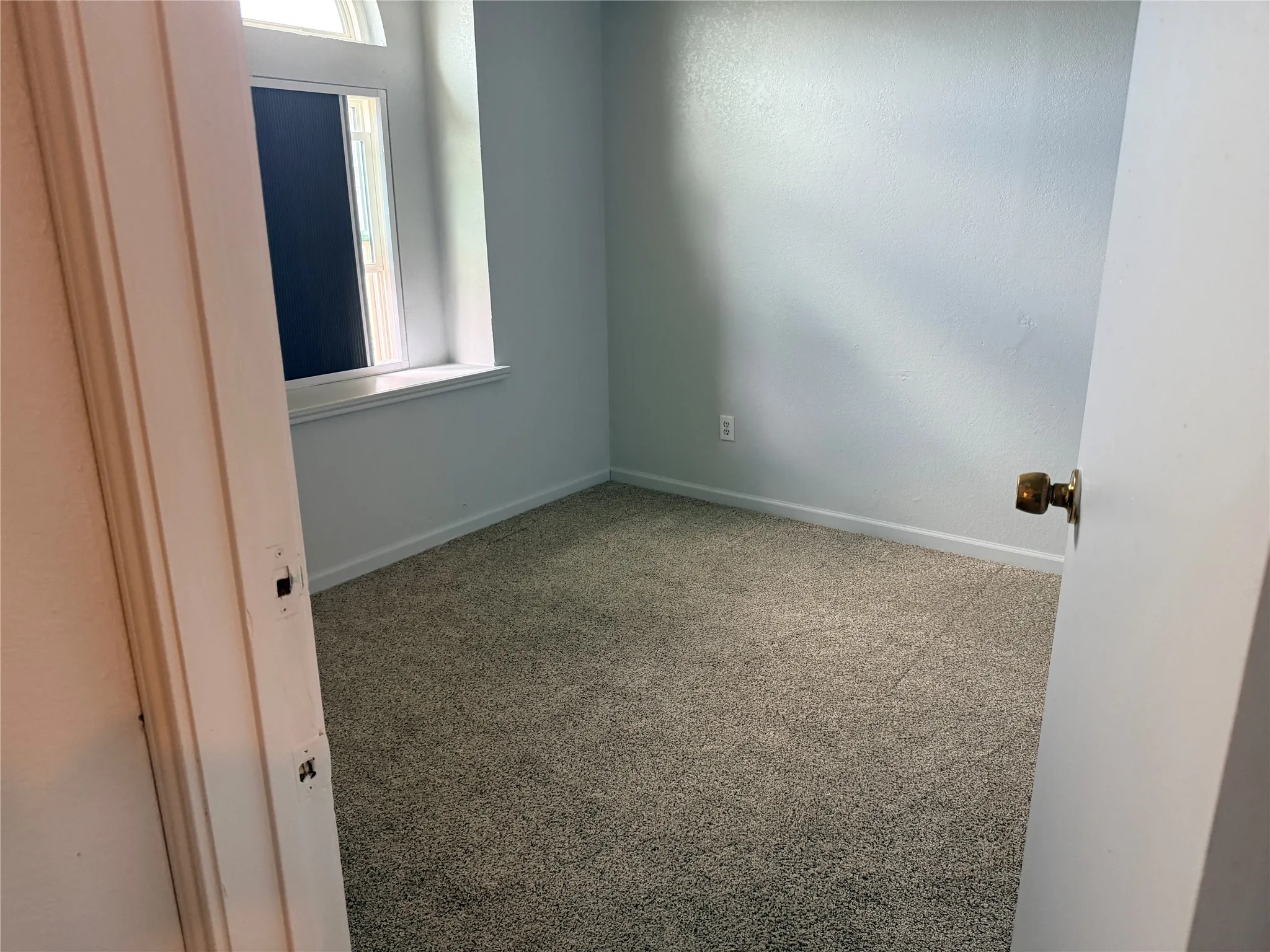 Wall-to-wall carpeting, light-toned wall finish, and a window with a deep sill