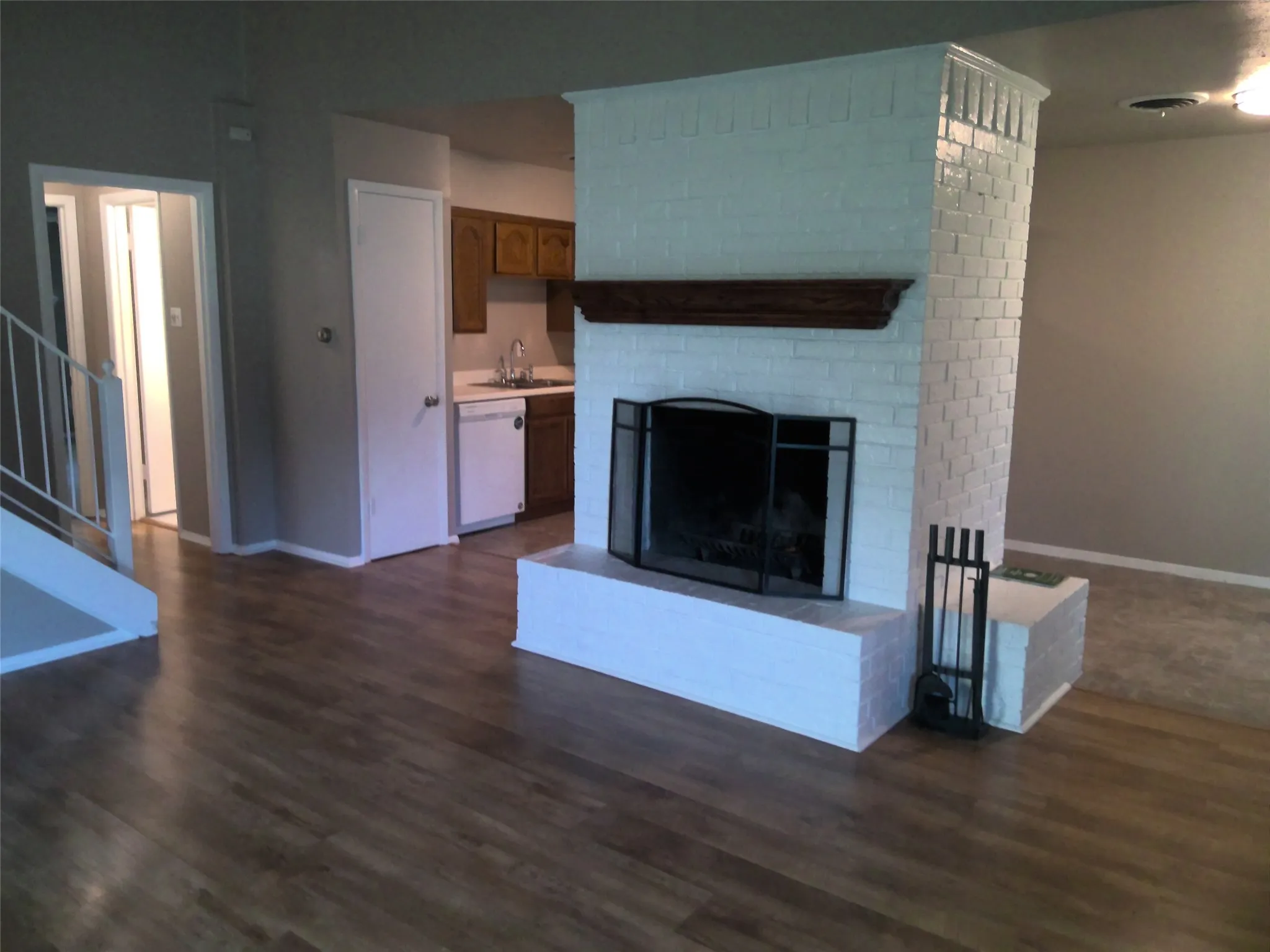 Fireplace faces the den and separates the breakfast and kitchen areas