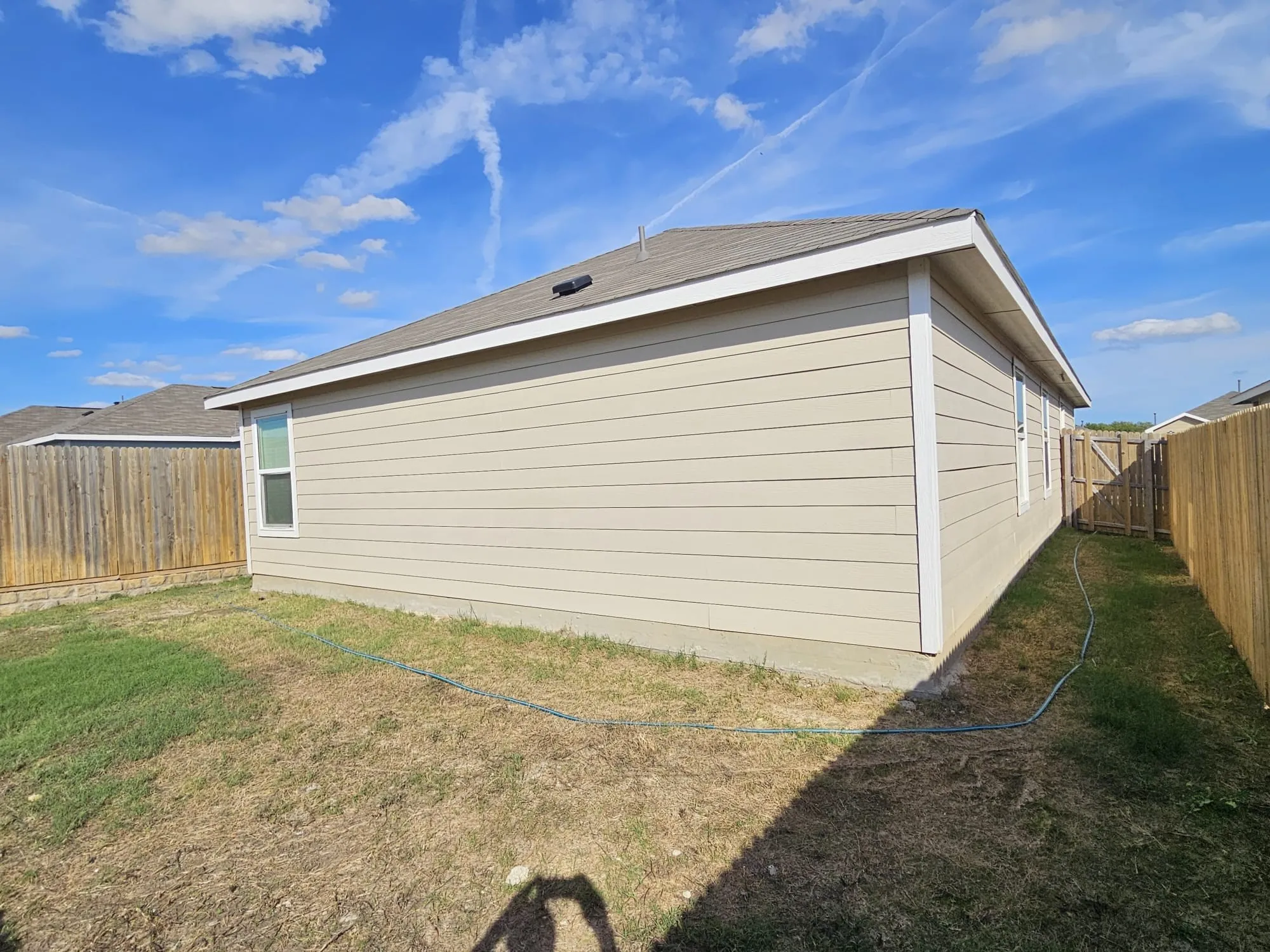 Exterior featuring horizontal siding, a fenced perimeter, and a pitched shingle roof