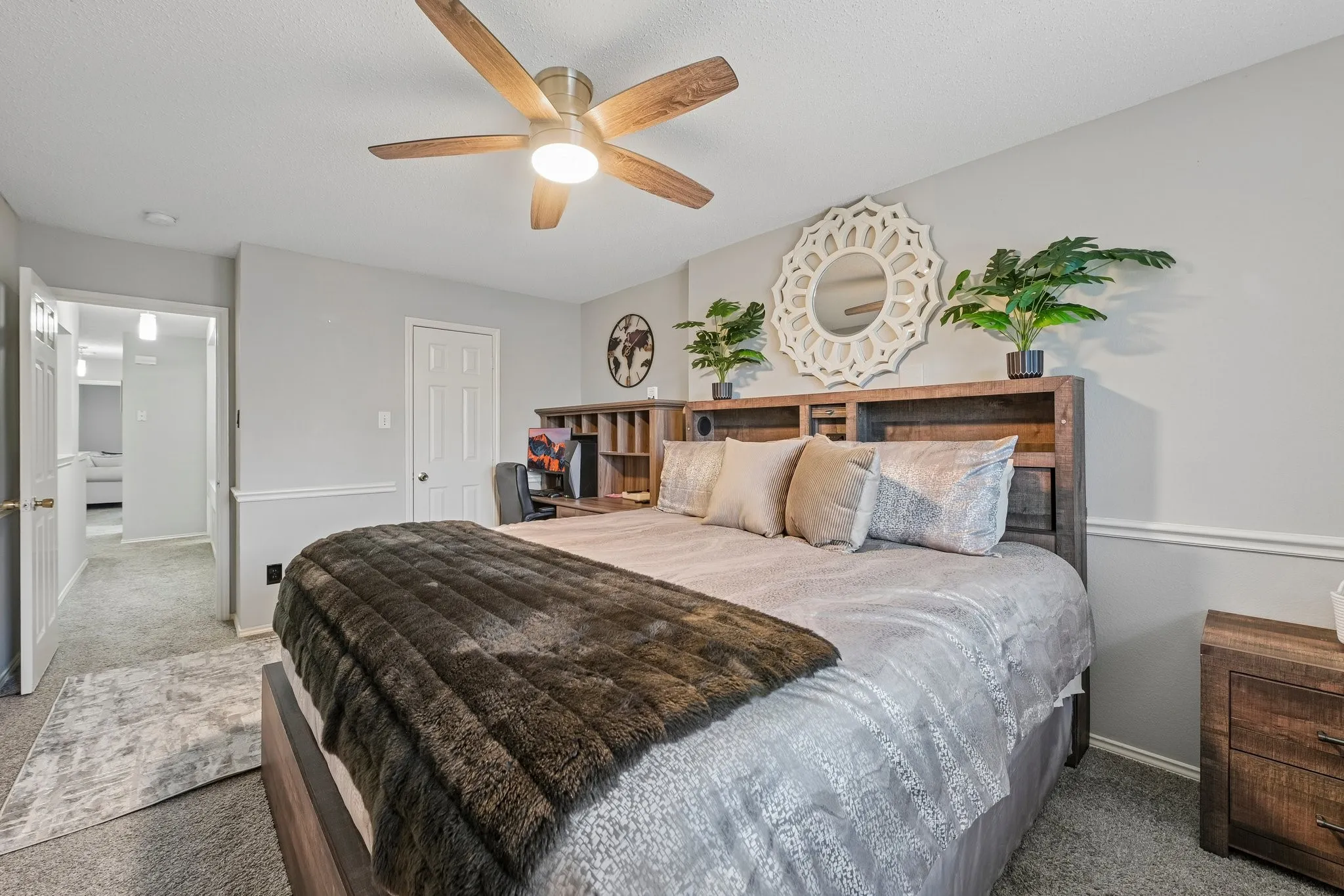 Carpeted interior with crown molding and a ceiling fan with integrated lighting