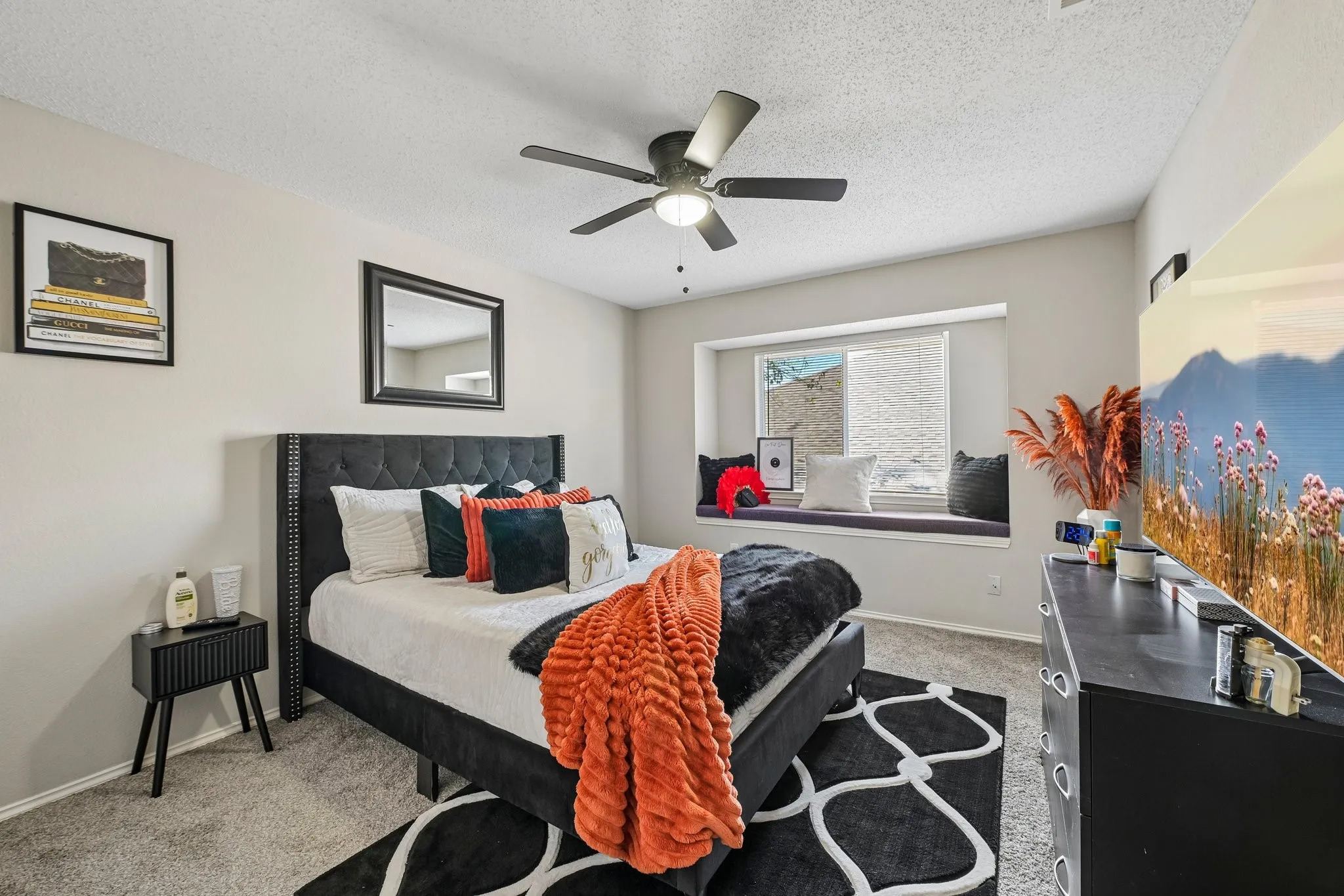 Recessed window seat, ceiling fan with integrated lighting, wall-mounted television, and carpeted flooring