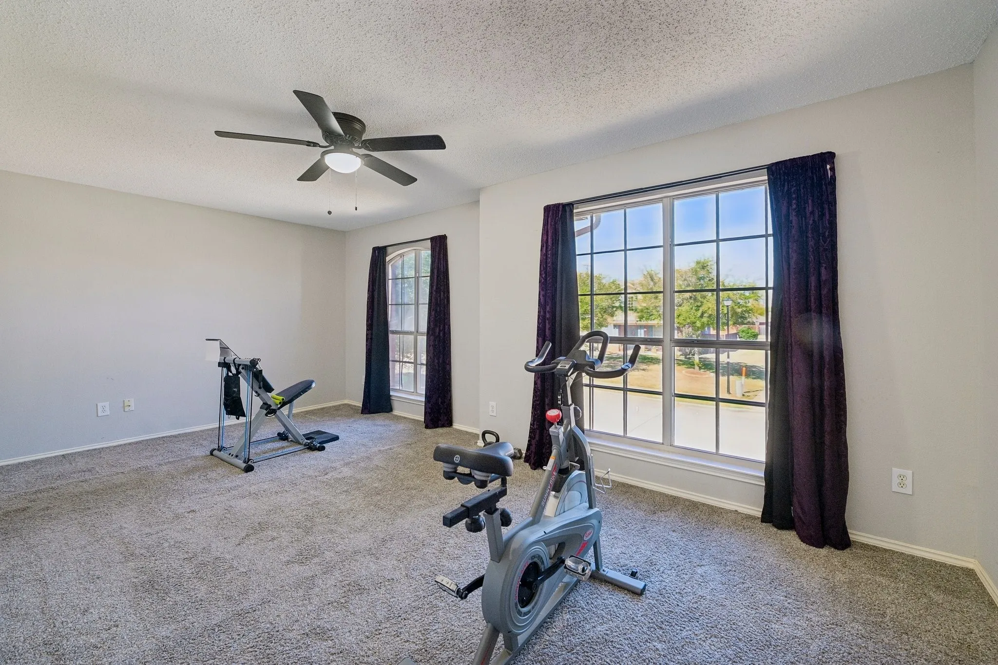 Recessed ceiling fan with integrated lighting, two multi-pane windows, and neutral wall paint