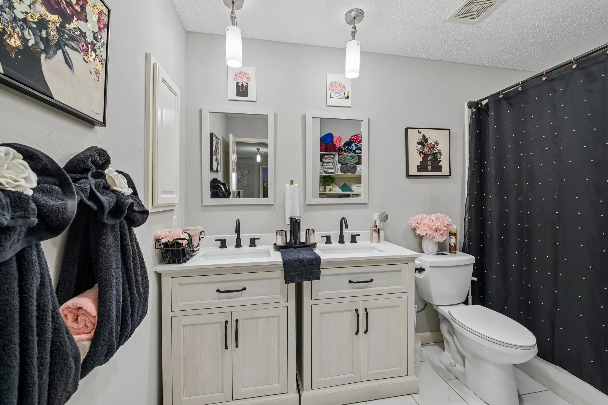 Dual single-basin vanities with matte black faucets, white countertops, and light cabinetry