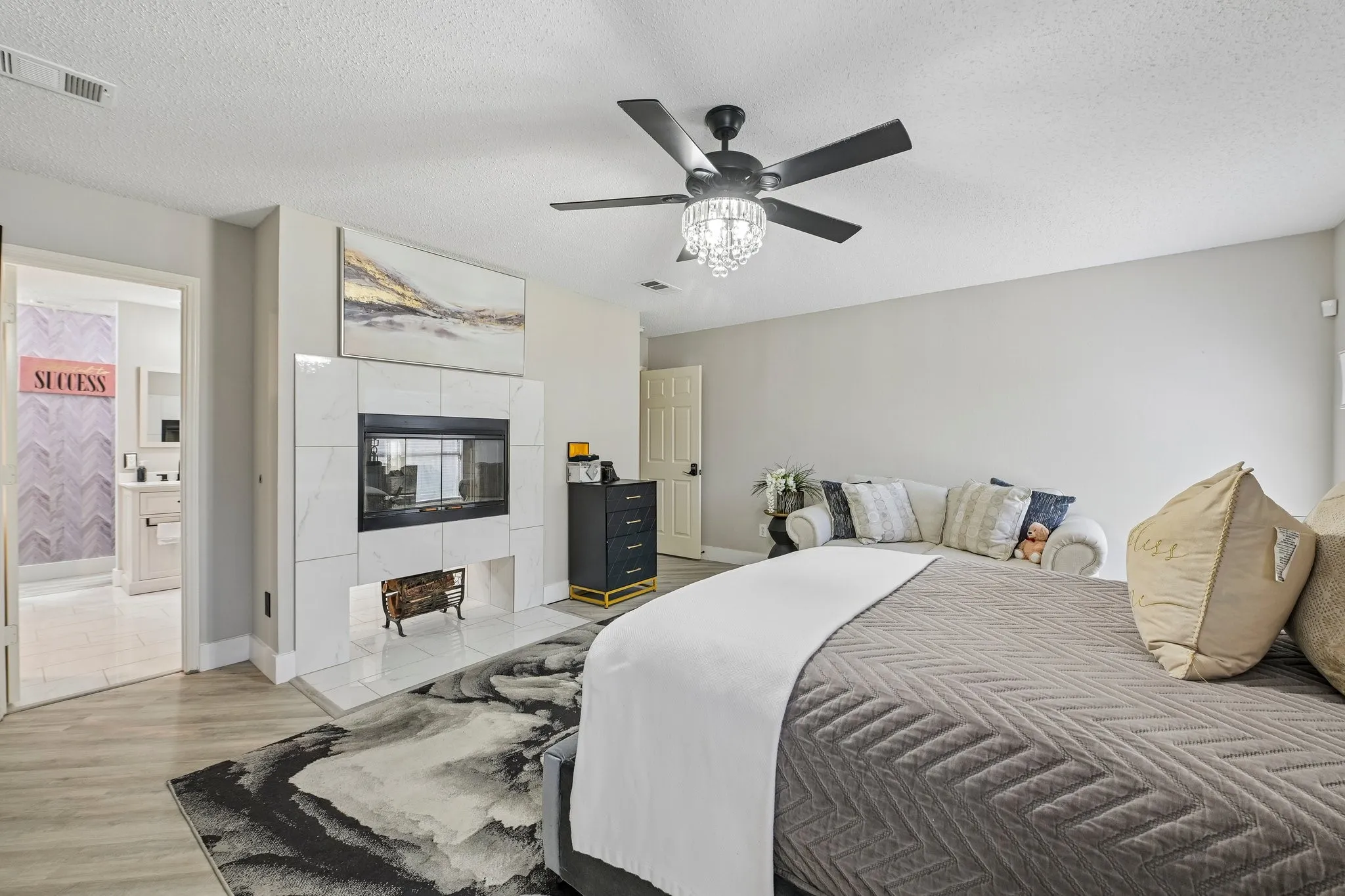 Fireplace with a tile surround, wood-finish flooring, recessed lighting, and a ceiling fan with a decorative light fixture
