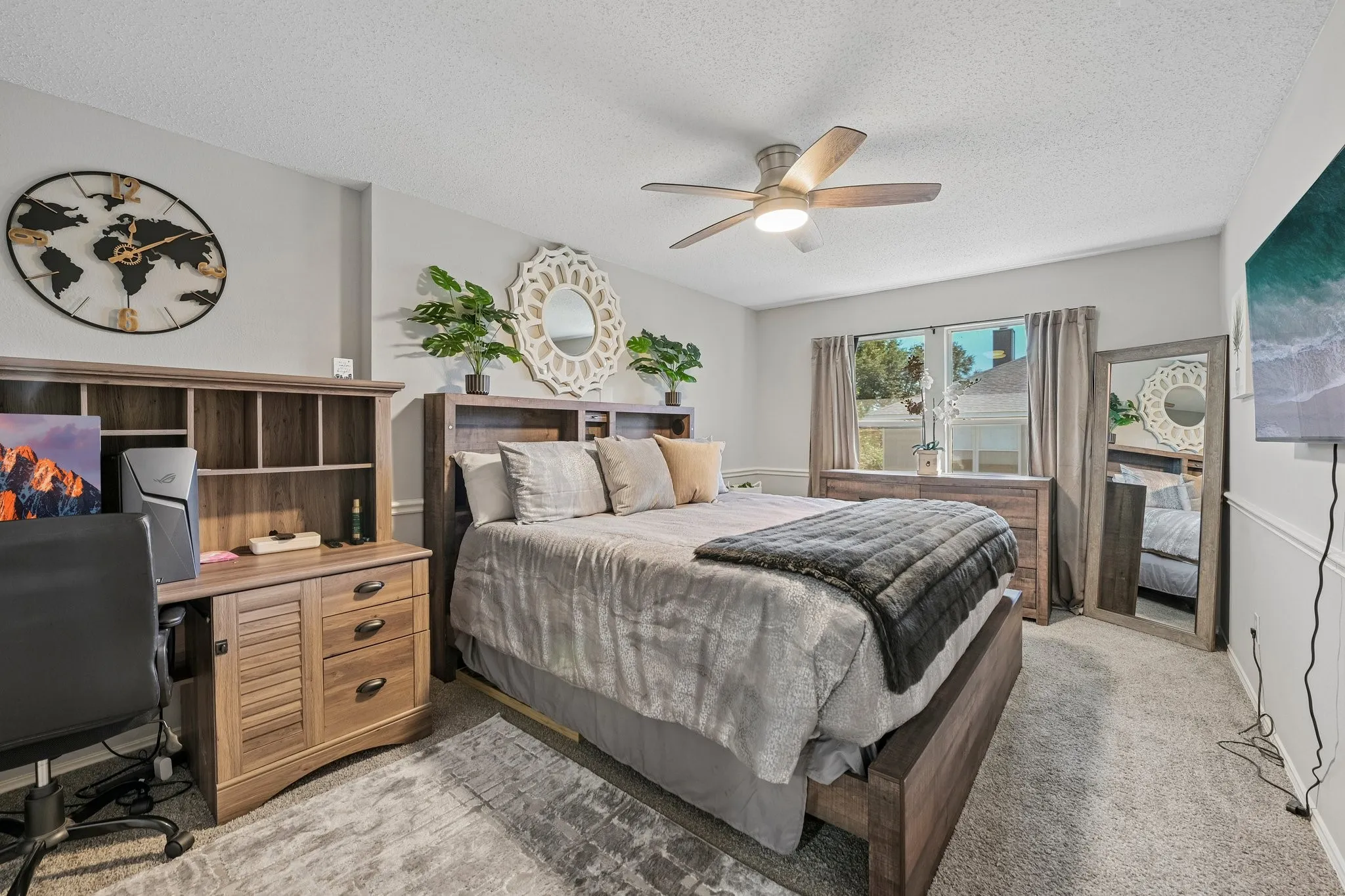 Integrated ceiling fan with lighting, carpeted flooring, window with natural light, and a built-in wall paneling detail